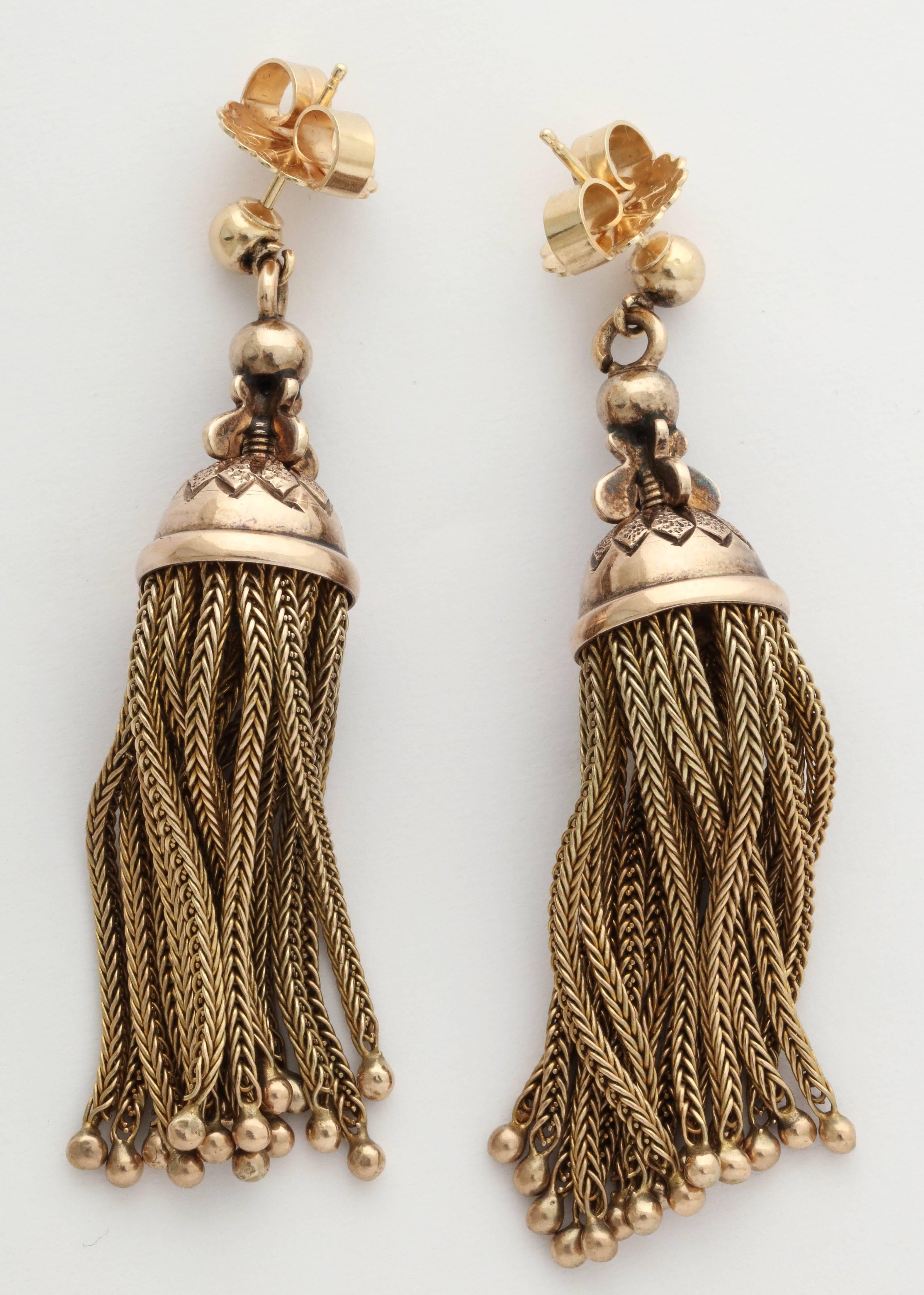 Fun tassels with great movement. This pair is 10k yellow gold and date to about 1890. The caps have lovely engraving and the tassels are finished with gold beads. 