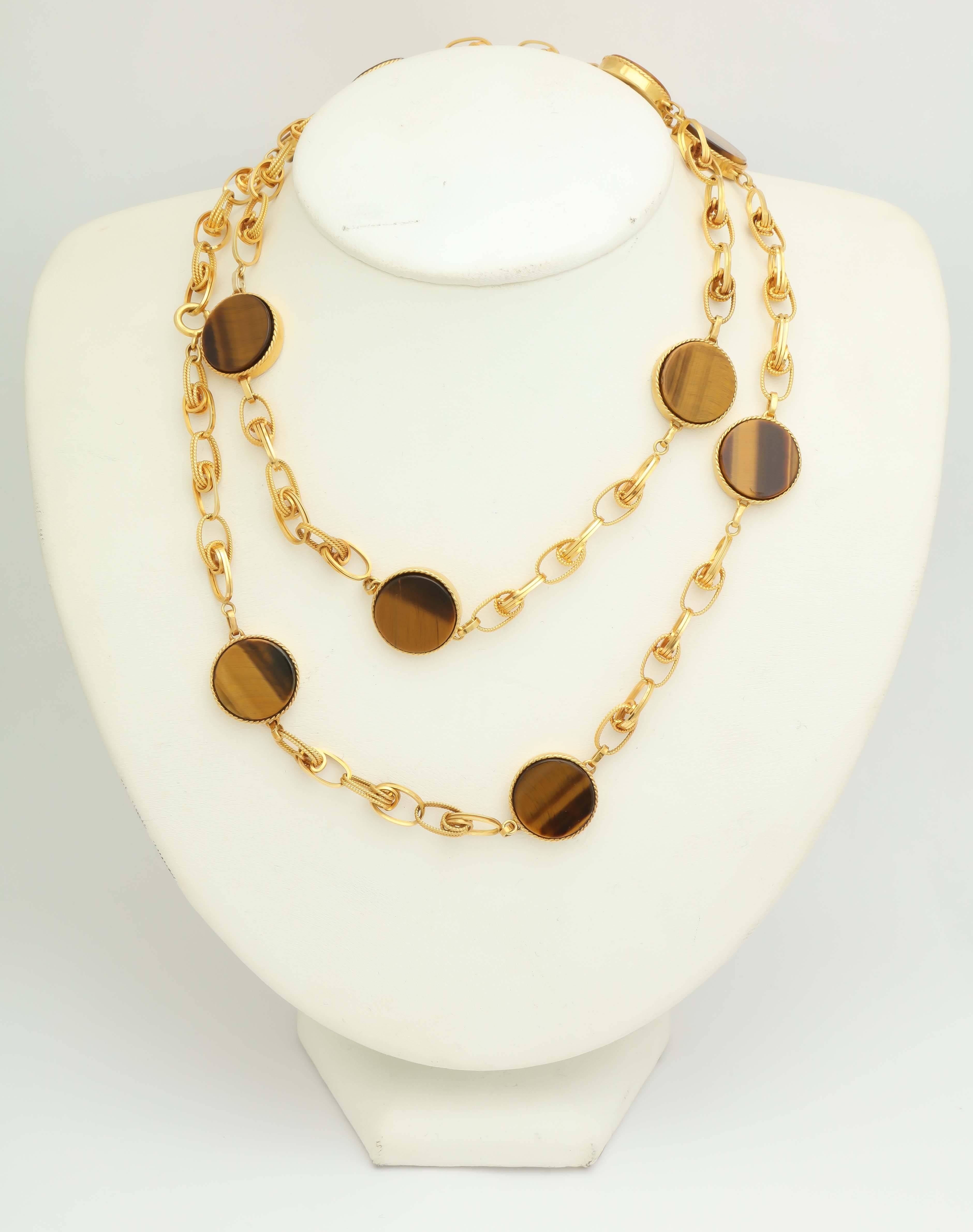 18kt Yellow Gold Ensemble Consisting Of A Long Chain/Necklace Designed With 10 High Quality Tiger's eye Stones in A Disc Style Motif Set In A Round Bezel Setting. Ensemble Also Exhibiting An Intertwined Open Link Design. Note: May Be Worn On The