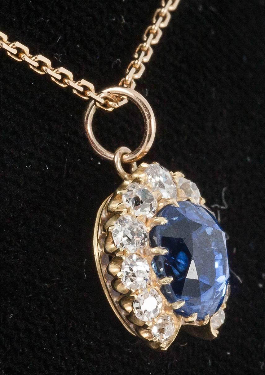 A natural cornflower blue ceylon sapphire of fine colour weighing approx 3.5 carats with a graduated line of old cut diamonds mounted in yellow gold,c,1870 as a horseshoe shaped pendant