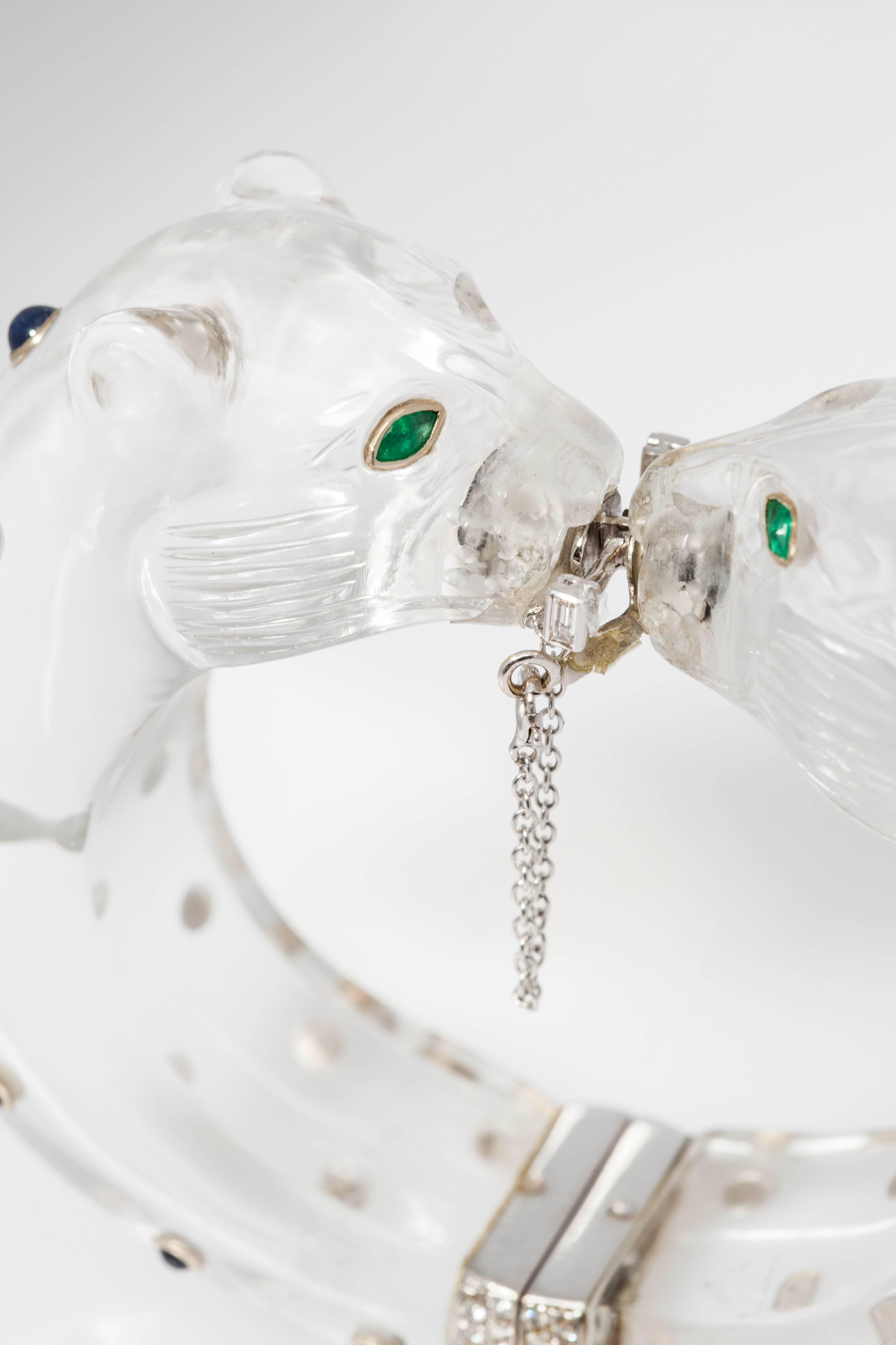 A bold panther bracelet, made out of carved rock crystal, embellished with cabochon sapphires and emeralds, as well as with diamonds in both in its upper and lower closing mechanisms. Mounted on 18kt white gold. Circa 1970 