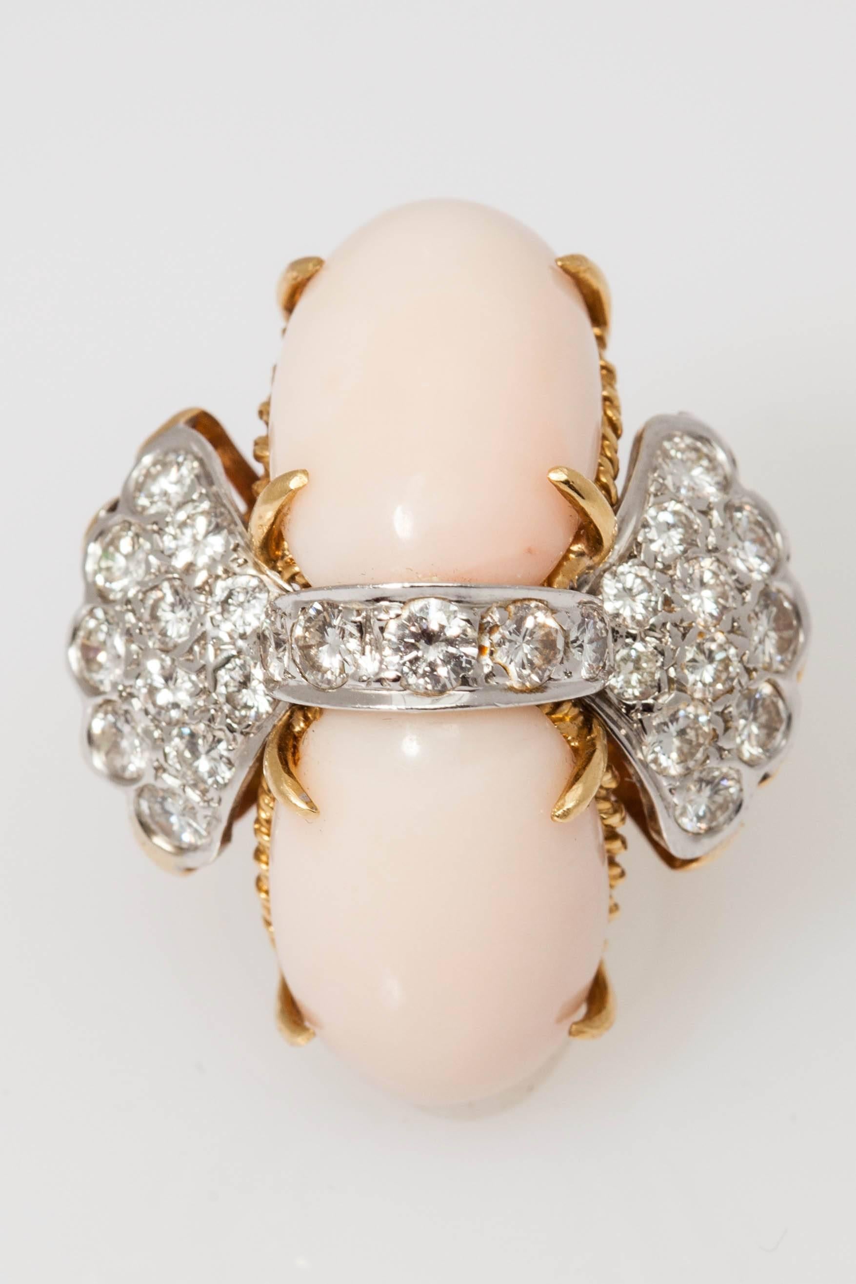 Ein raffinierter, flügelförmiger Cocktailring, verziert mit feinen Diamanten im Brillantschliff und zwei ovalen Elementen aus Lichtkoralle. Montiert auf 18kt Gelb- und Weißgold. Circa 1960. 