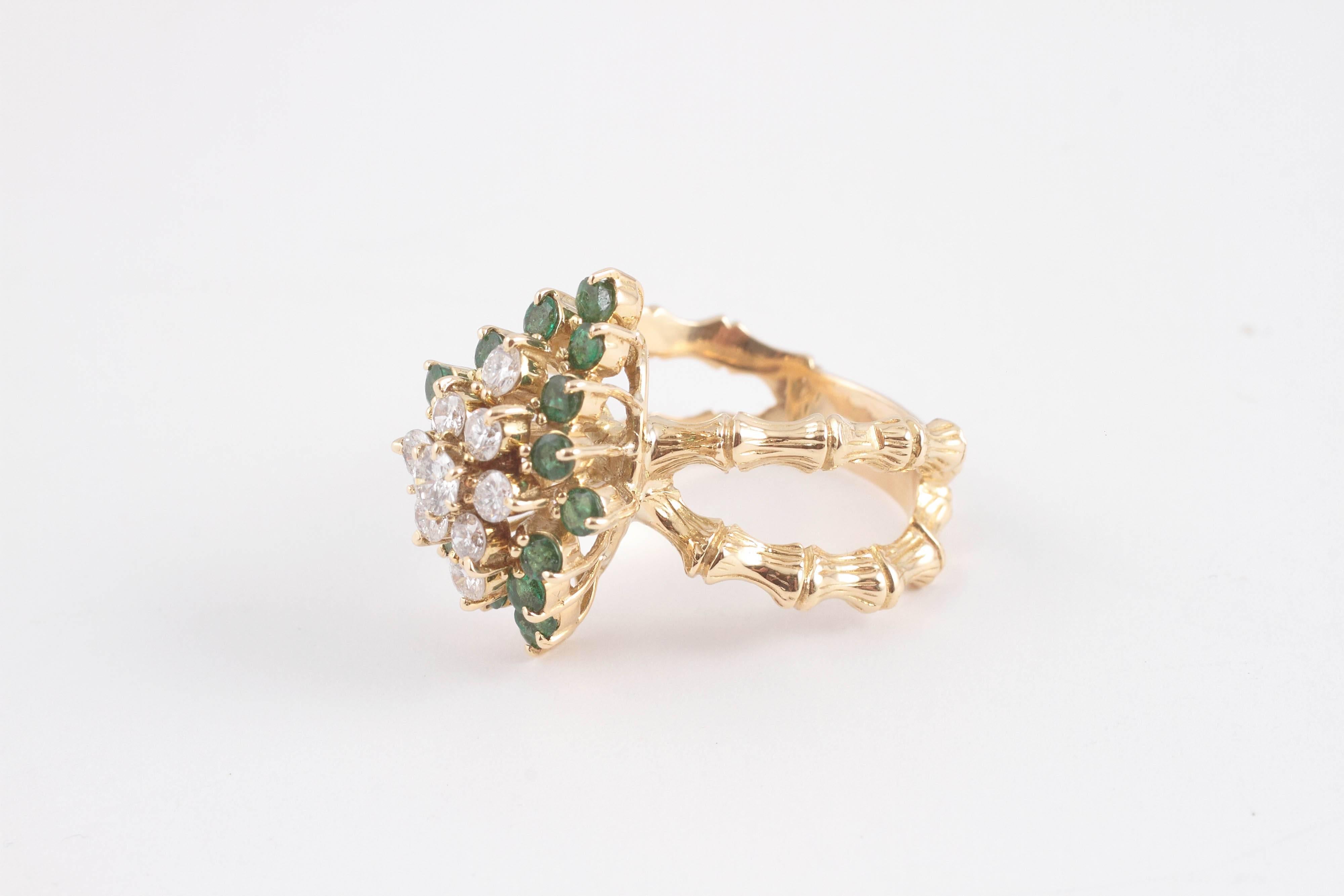18 karat yellow gold bamboo style double shank set with a marquise shape cluster of diamonds surrounded by emeralds.  A fun and fanciful feel to the whole ring.  Size 9 1/2