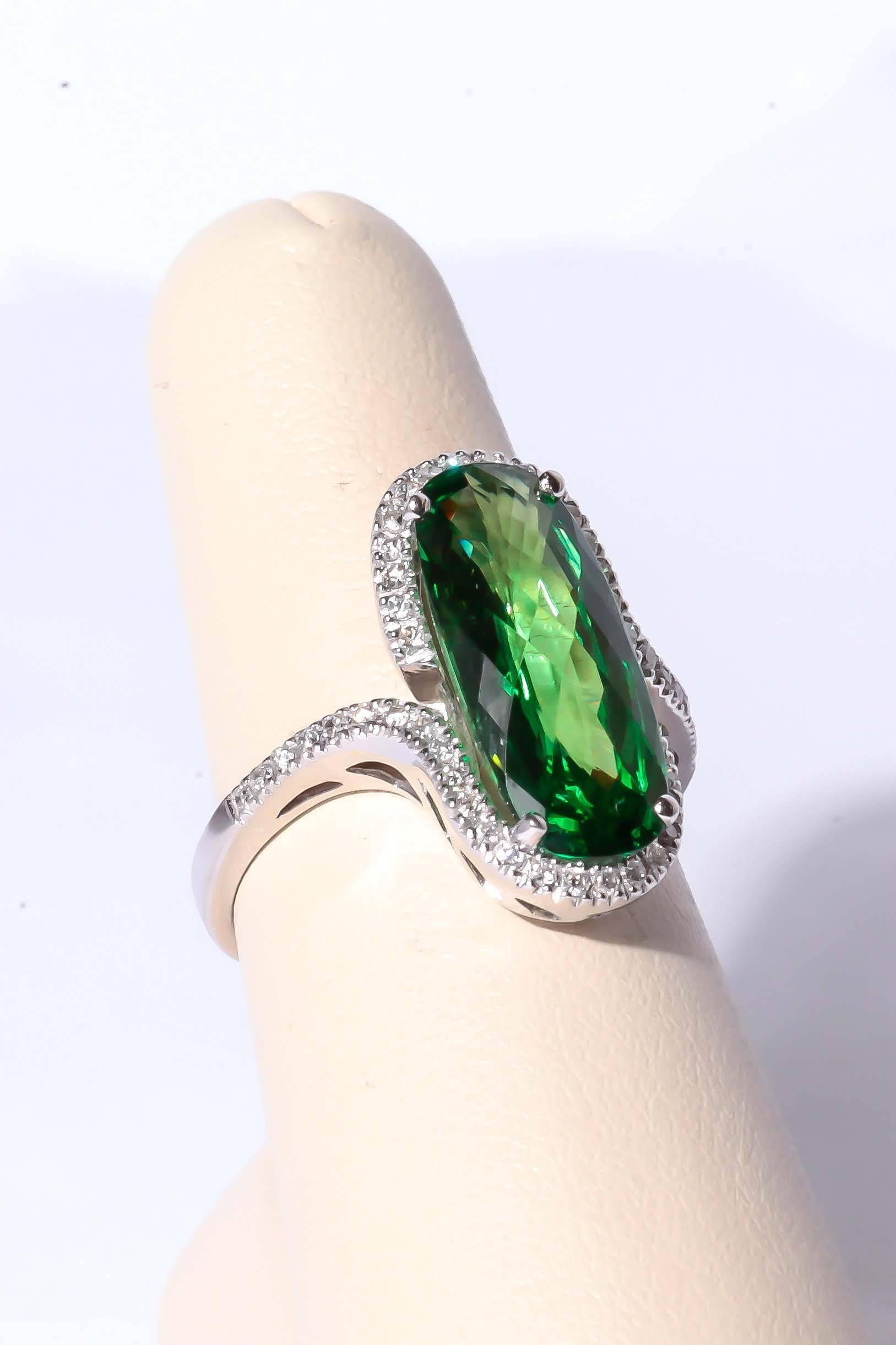 Tsavortie and diamond 18k white gold ring designed by Gadi. Ring is mounted with an usually large oval elongated tsavorite weighting approximately 5.62 carats the Tsavorite measures 18.19/7.74/5.09 mm Surrounding tsavorite are small diamonds in a