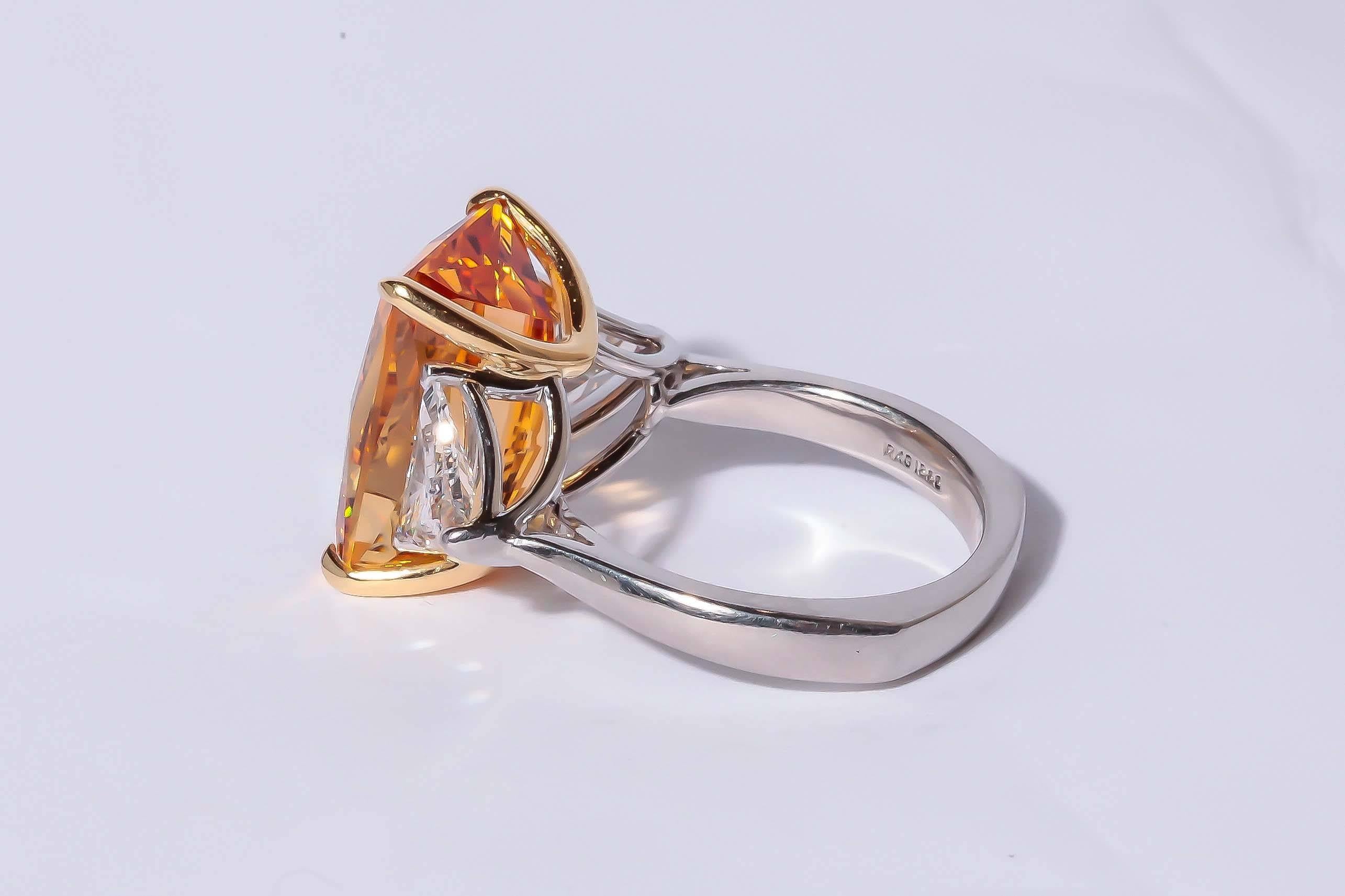  Richard Krementz one of a kind platinum and 18KT yellow gold, Precious Topaz and diamond ring. The Topaz is a faceted Emerald cut weighing approximately 12.25 carats. Trillion shape diamonds flank the sides of the topaz and have a total weight of