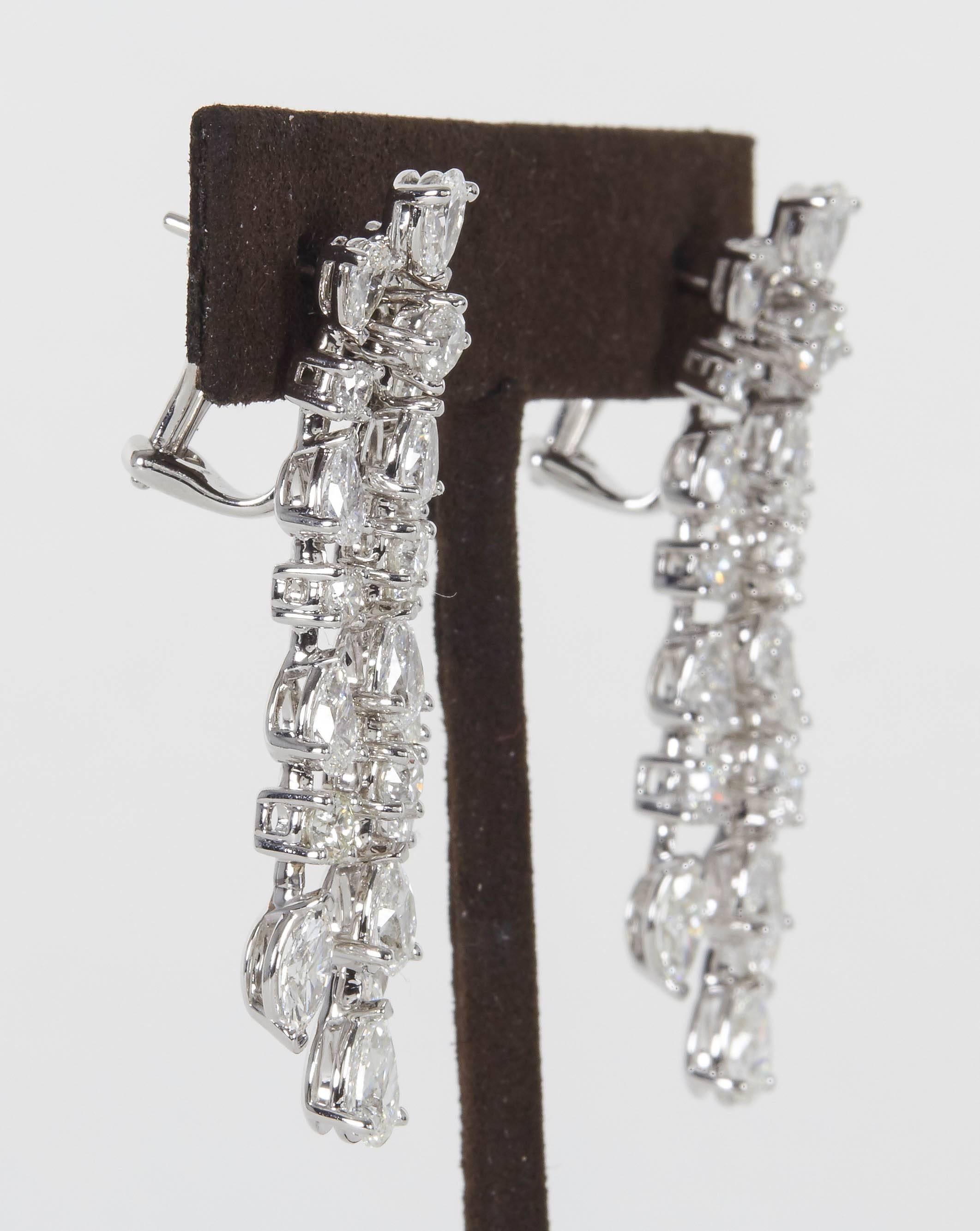

A stunning pair of earrings featuring round, pear and marquise cut diamonds. 

9.91 carats of large sized diamonds F/G VS.

18k white gold 

They measure approximately 1.77 inches from the top to bottom of middle row. 

This earring will