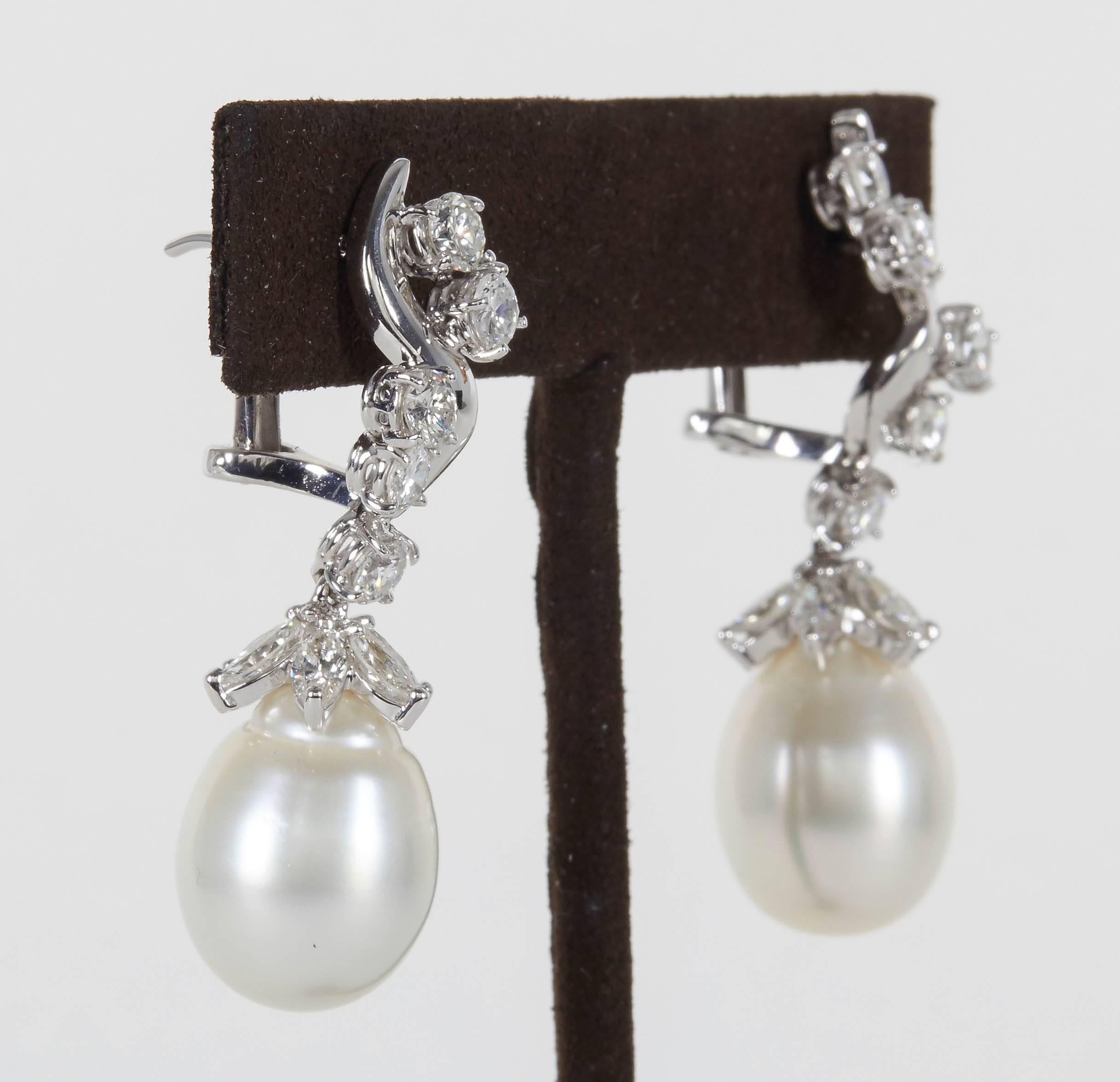A stunning pair of earrings in a timeless design. 

3.60 carats of round brilliant and marquise cut diamonds.

12 MM pearl.

18k white gold 

Approximately 1.57 inches in length