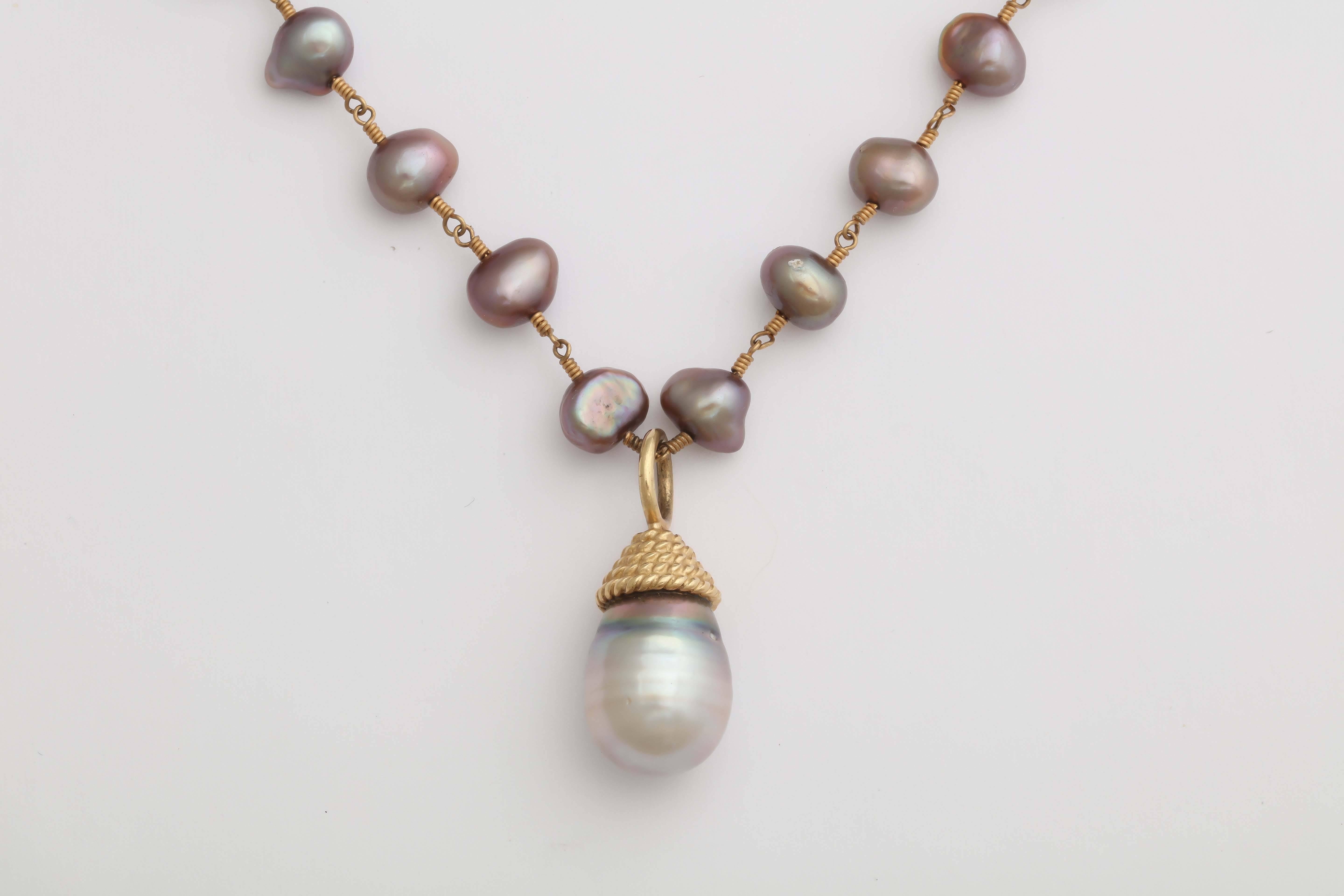 Great gray Tahitian pearl  wrapped with a 14 kt gold Twisted wire cap pendant  necklace.
Holding the drop pearl is a 14 kt wire fresh water pearl chain. Total length 16.5 in. It can be made longer at your request.. The necklace is finished with a