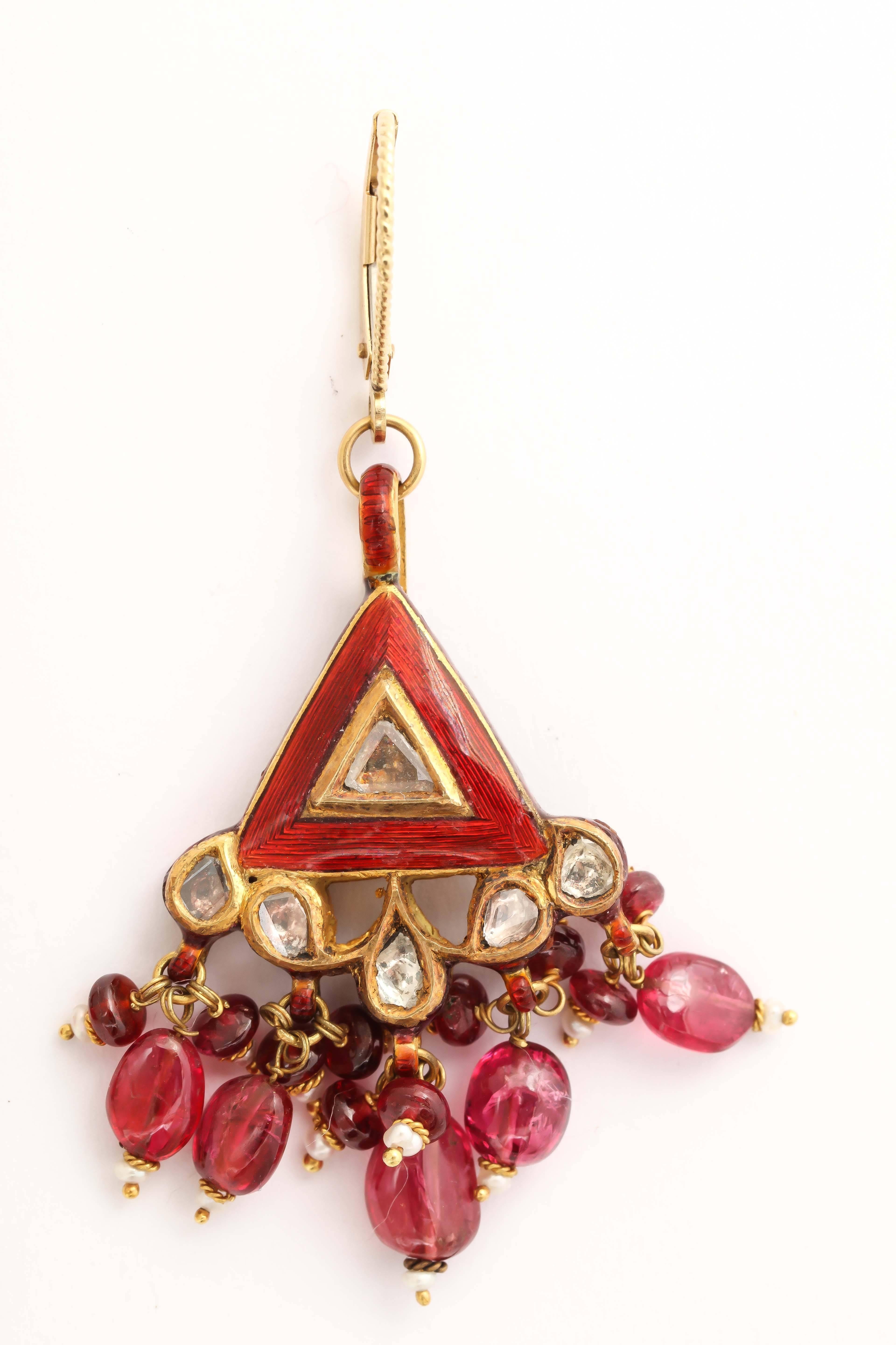 These exquisite red enamel earrings are festooned  with ruby, red spinel and pearl dangles. In the center of the red enamel is an Indian diamond, they're called polki. They are flat slices of diamonds and the others are rose cut diamonds. The back