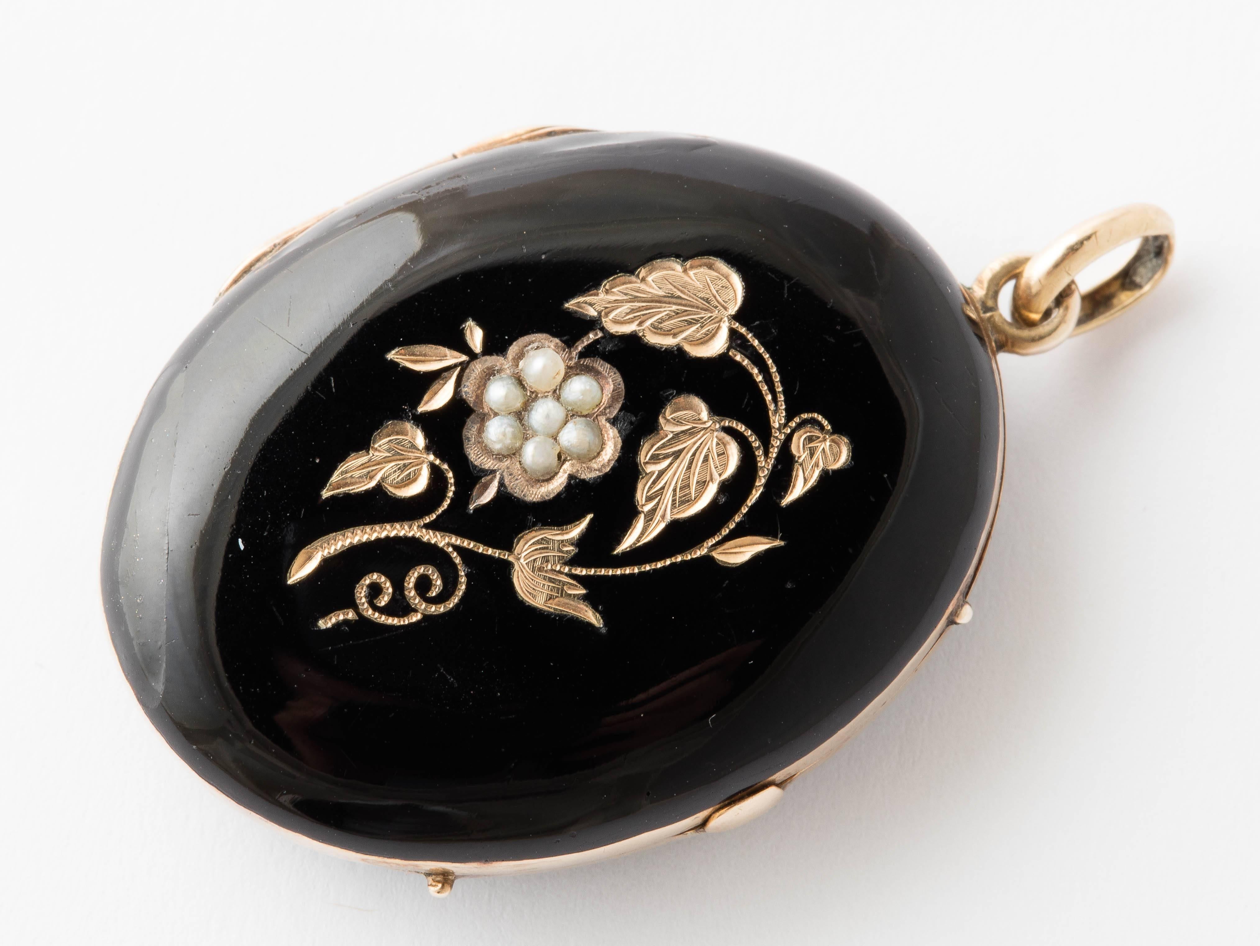 14K and black enamel Victorian oval locket. Front has engraved leaf and grape design in gold. Grape cluster is made of seven seed pearls. Back is entirely black enamel.