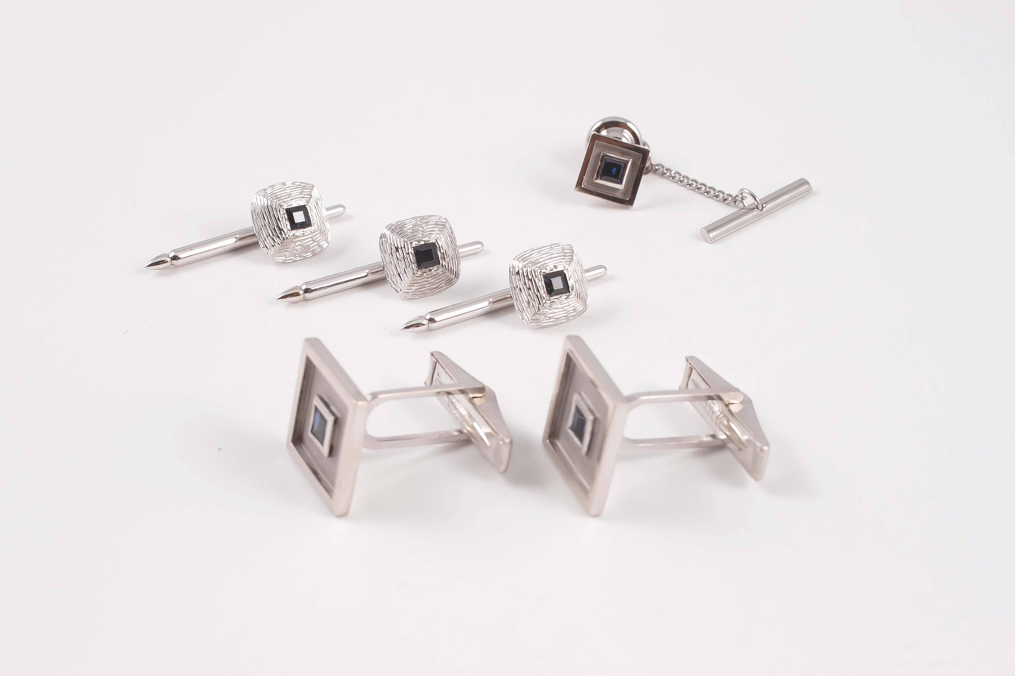The cufflinks and tie tack have a clean modern look with sapphires set into square shaped bezels. The cufflinks measure 20.00 mm square.  The shirt studs have a domed shape with a textured surface to complete the look.  