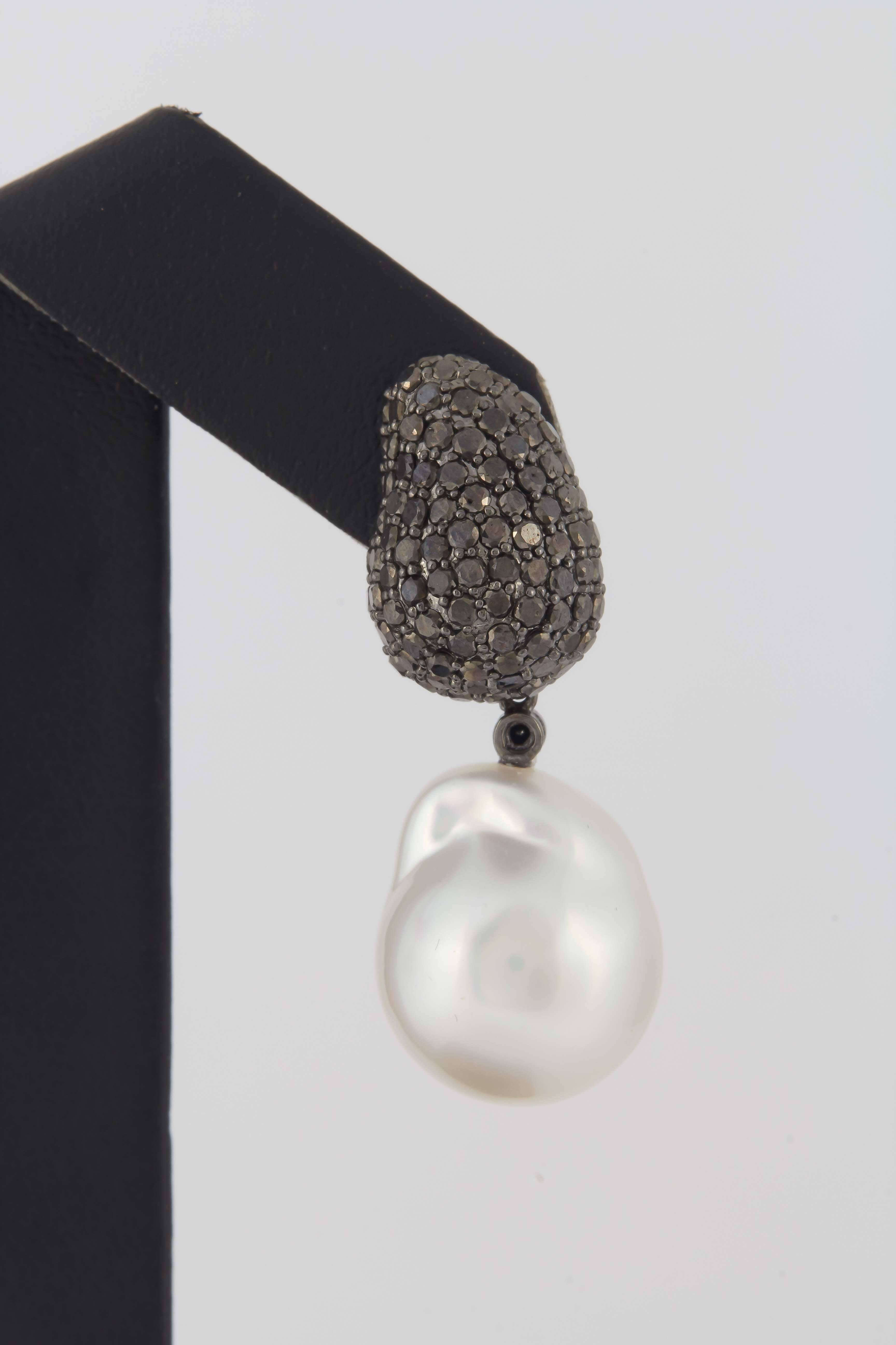 18K White gold drop earrings featuring black diamonds weighing 3.10 carats and two South Sea Pearls measuring 13-14 mm. 

Pearls can be removed and wear just the diamonds. 