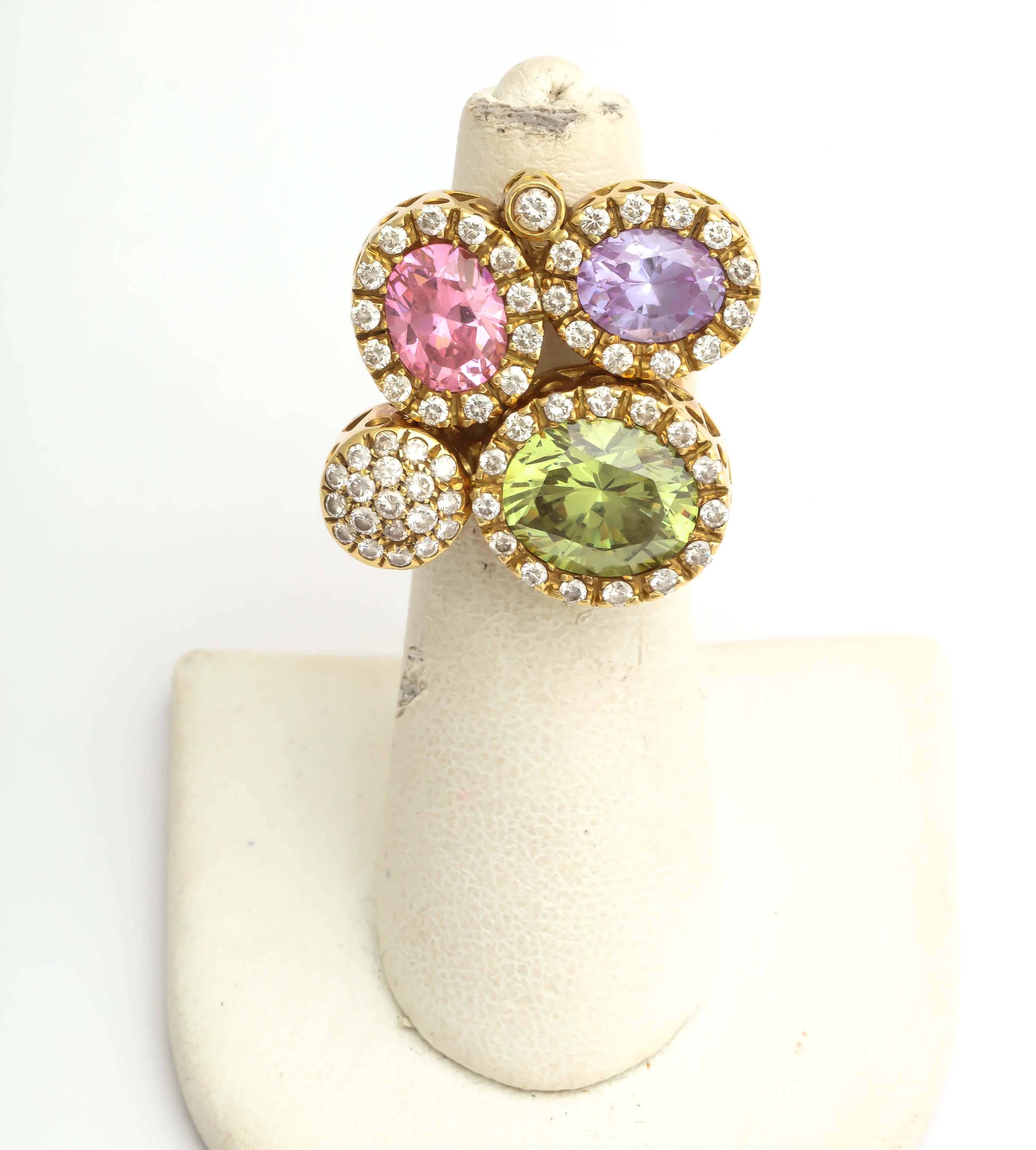 18kt Yellow gold large cocktail ring embellished with 3 pastel-colored stones of 1 peridot, 1 amethyst and 1 pink tourmaline stone throughout, weighing approximately 3.5 carats each. Further designed with numerous full-cut diamonds weighing