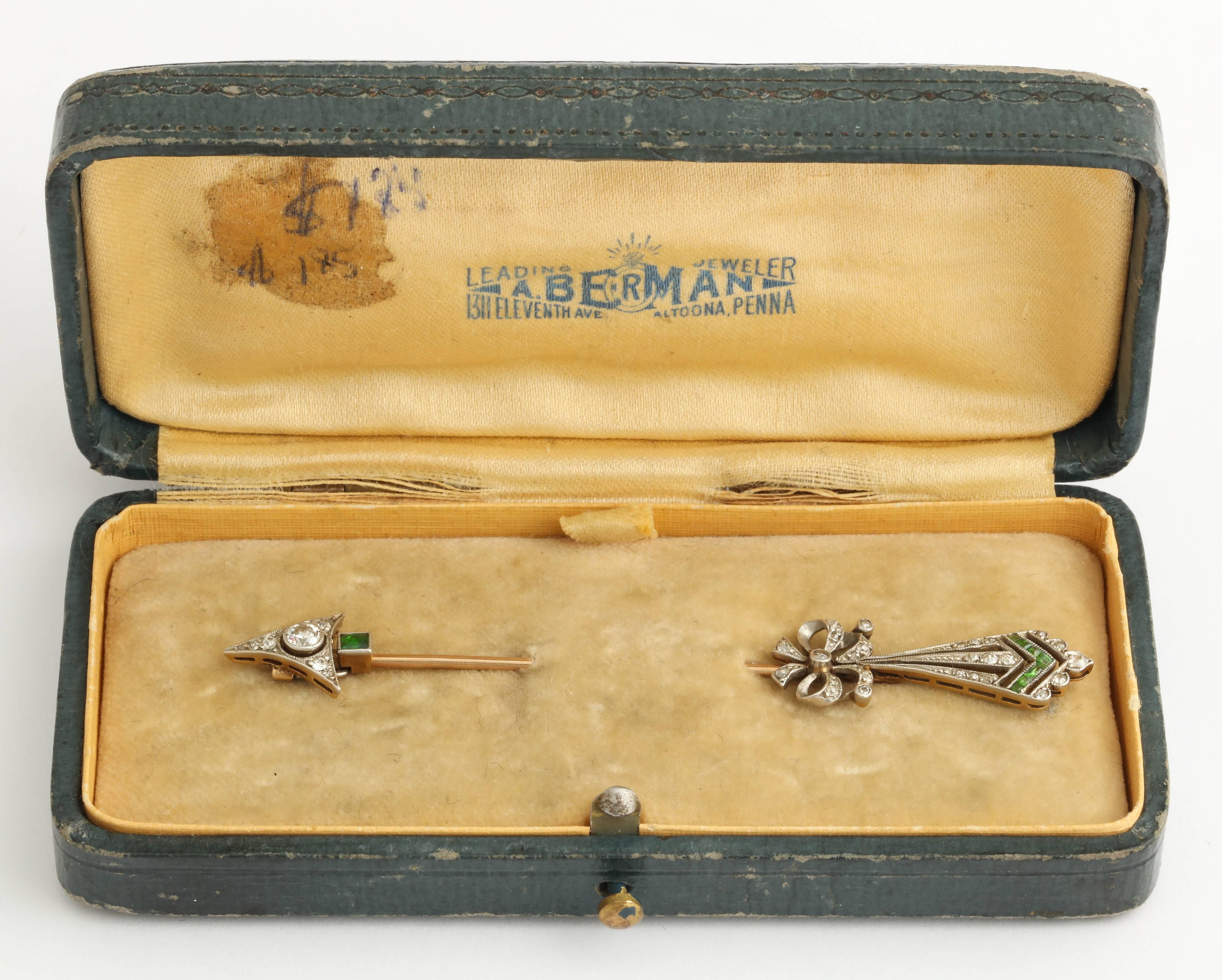 Stunning platinum on 18k yellow gold arrow brooch in original fitted box. It is American made c.1920. The brooch is set with emeralds and old cut diamonds