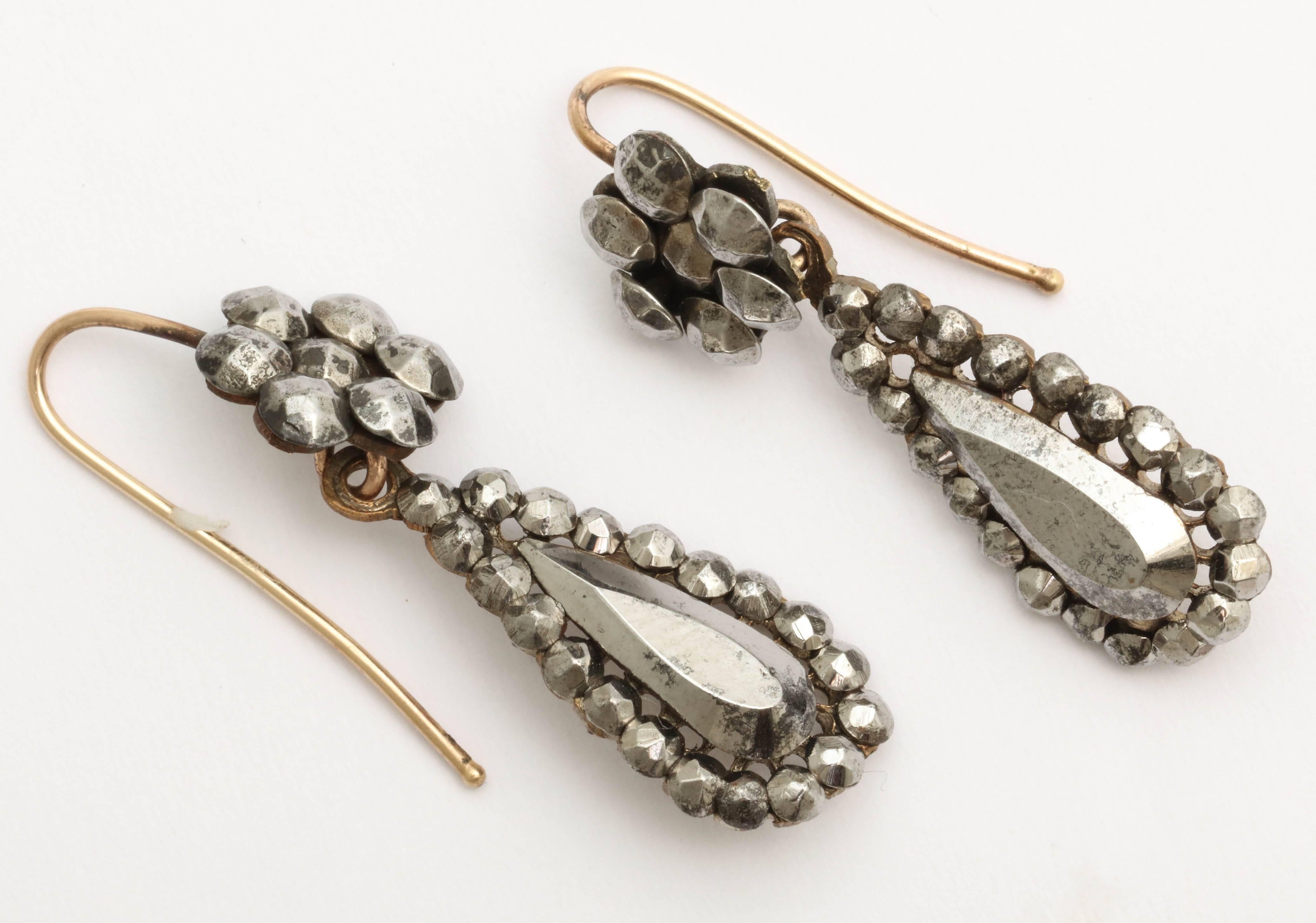Easy to wear and beautifully made, these cut steel earrings with gold backs and ear wires date to the 1860s. A tear drop shape cluster dangles from the floral cluster top. 
