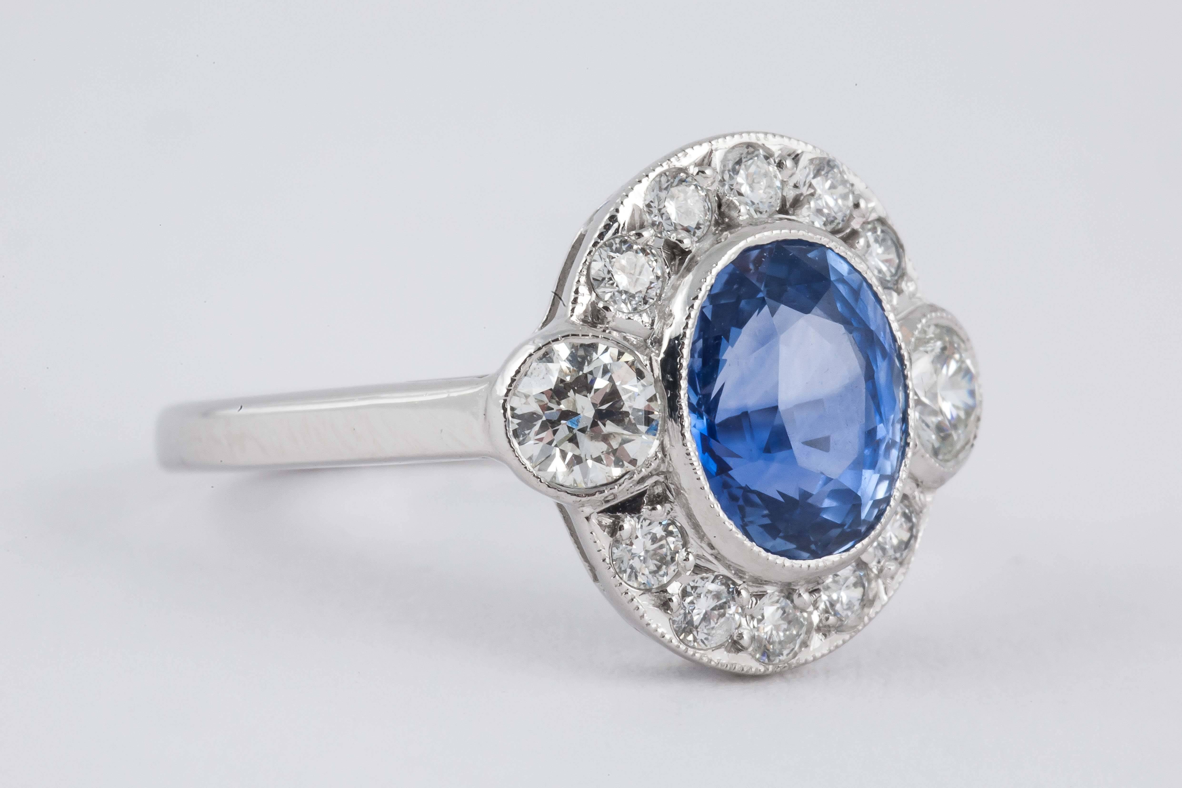 A twelve stone, old brilliant cut diamond cluster ring with a pale Ceylon sapphire centre, mounted in 18 carat golds, 1990