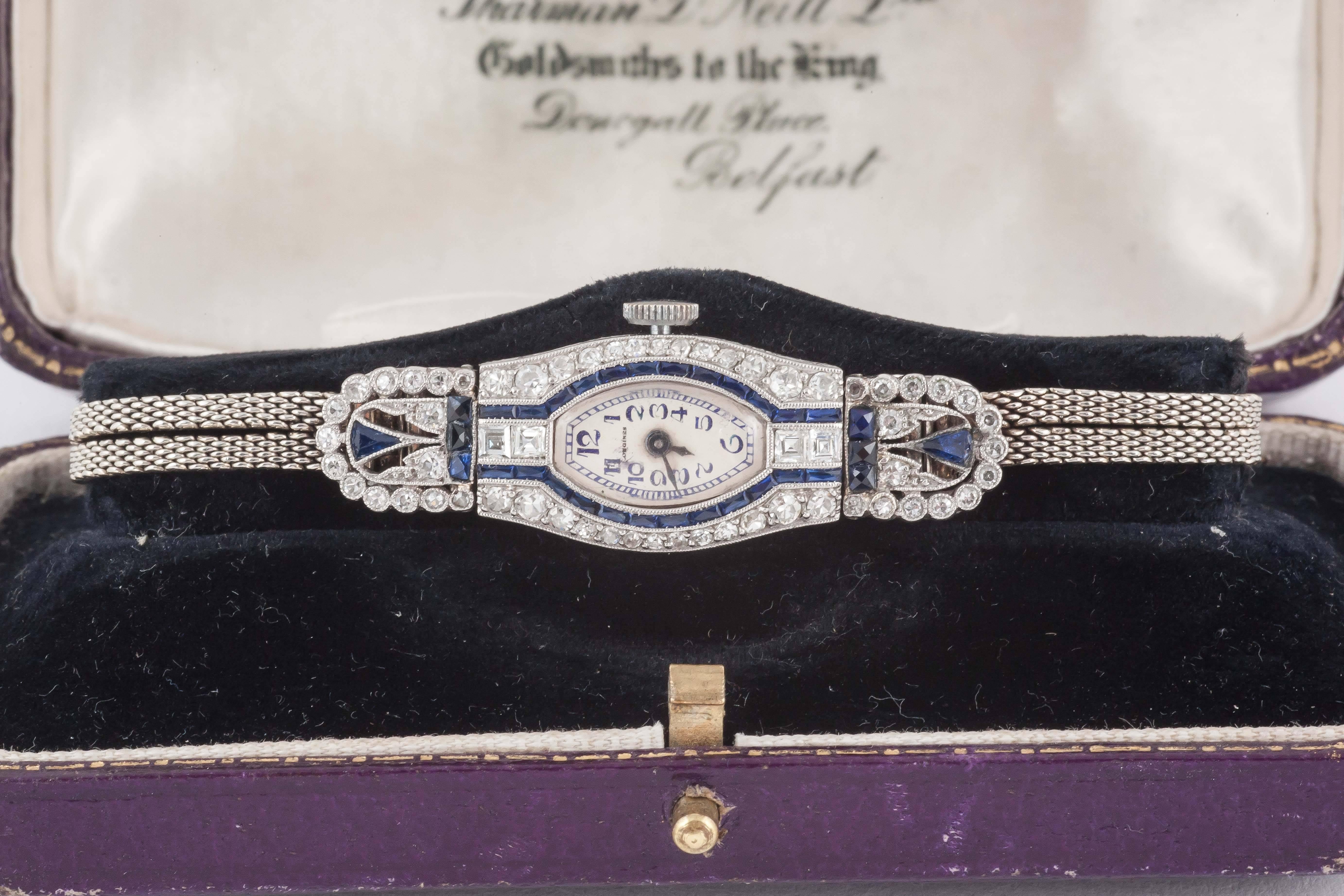 A fine platinum and 18carat White gold ladies evening watch set with diamonds and sapphires ( some sapphires synthetic) with original certificate dated 1924 and original case. On twin stranded bracelet, original longines lever movement with