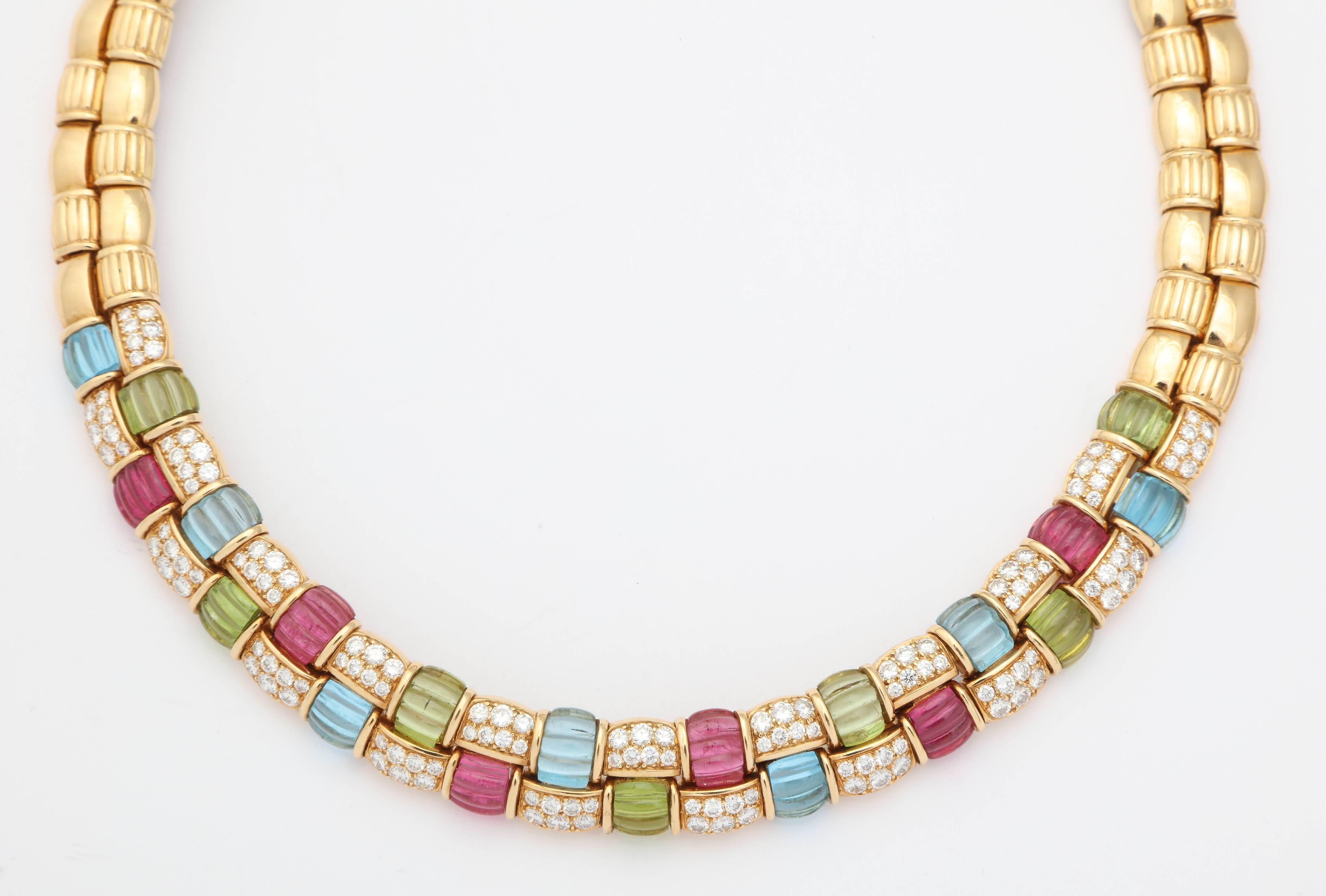 18kt  double row necklace set with Rubellite,  Peridot, and Blue Topaz  ribbed stones and very clean  - full cut, white Diamonds.  A  slender colorful ribbon = clean,  and sumptuous - an era past but not over yet.  
