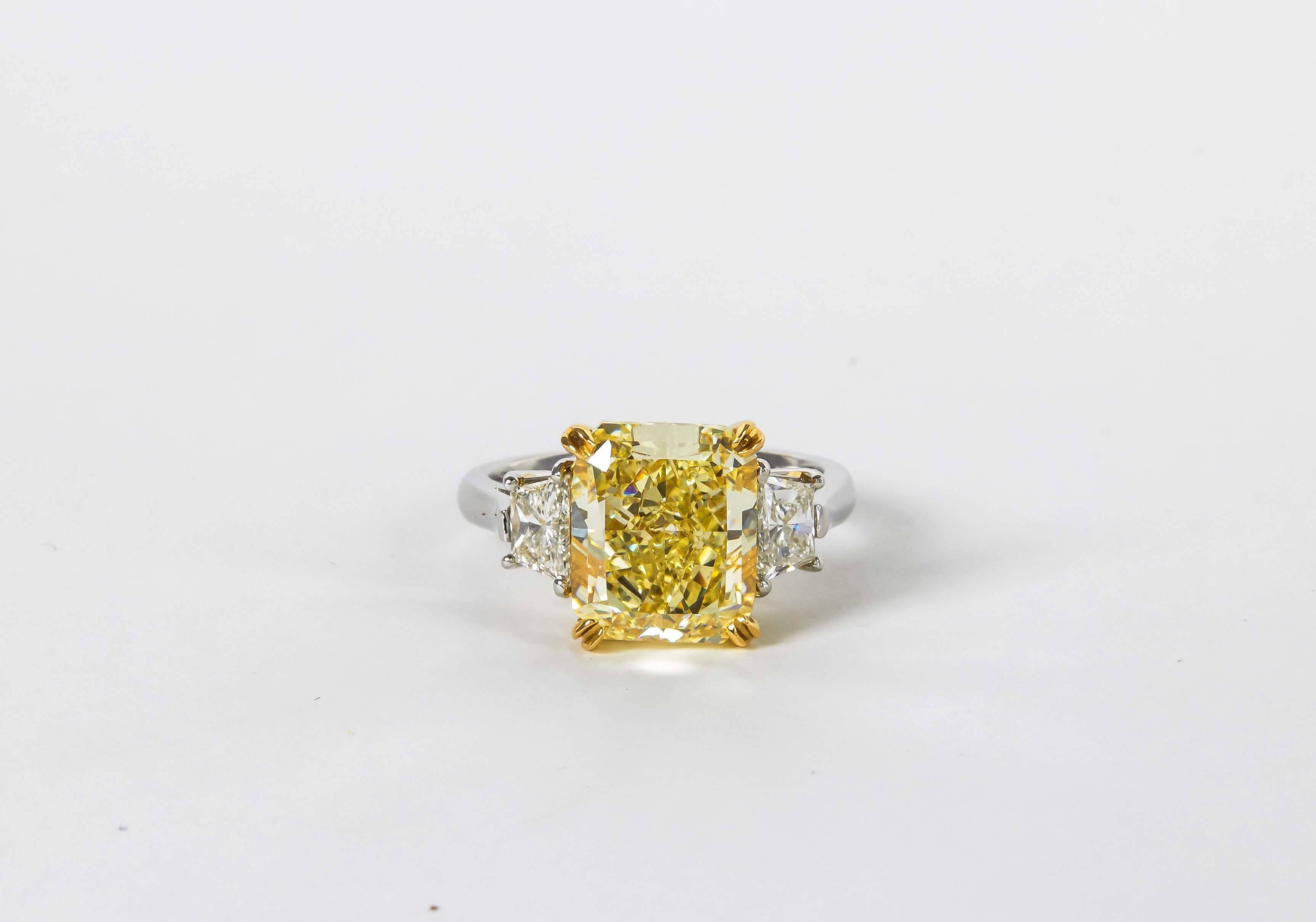 

An incredible yellow diamond! 

Just under 6 carats and a step away from FLAWLESS!

5.62 carat Radiant cut Fancy Yellow VVS1 center diamond set with white trapezoid cut diamonds weighing .84 carats. 

Currently a size 6+ , but can easily