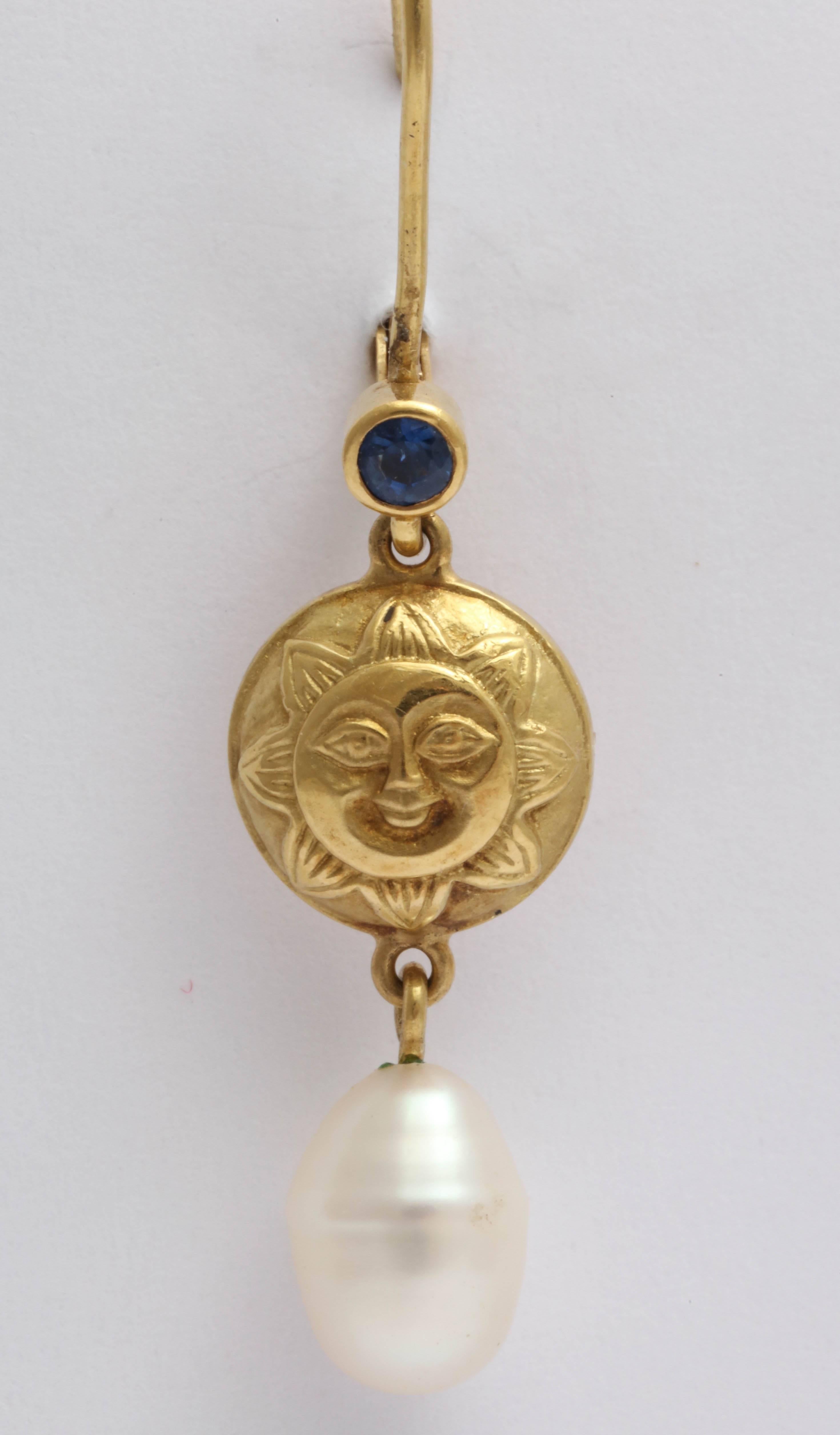 Heavenly sun and moon disks suspended from top top by bezel set faceted sapphires with a fresh water pearl drop dangling from the bottom. The earrings hangs from secure Euro-wires.