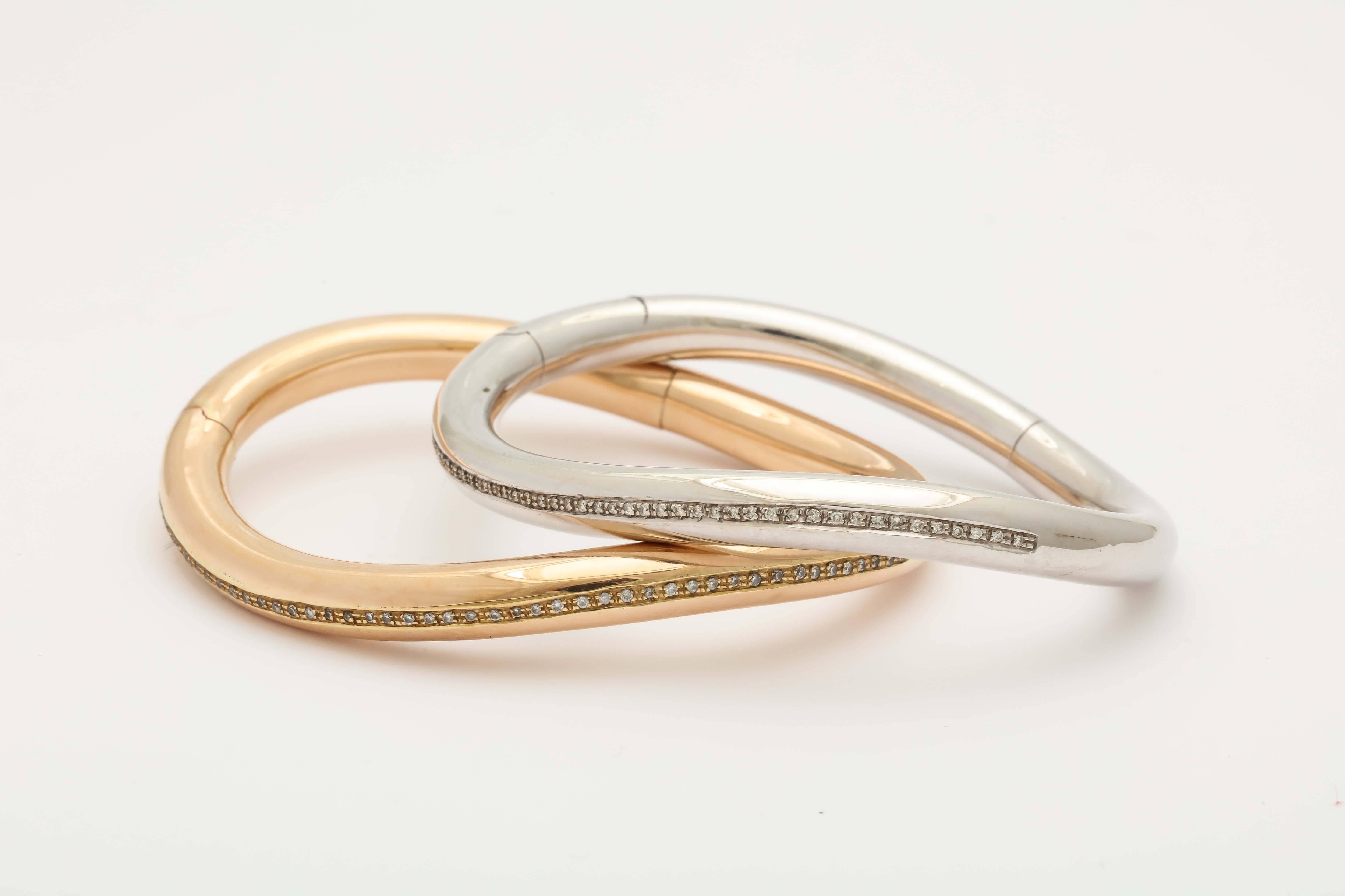 Pair Of 18kt Gold White And Rose Gold Bangles With 2 Stripes of Diamonds Weighing Approximately 1 carat total weight. Designed By Faraone Mennella. in the 1980's.