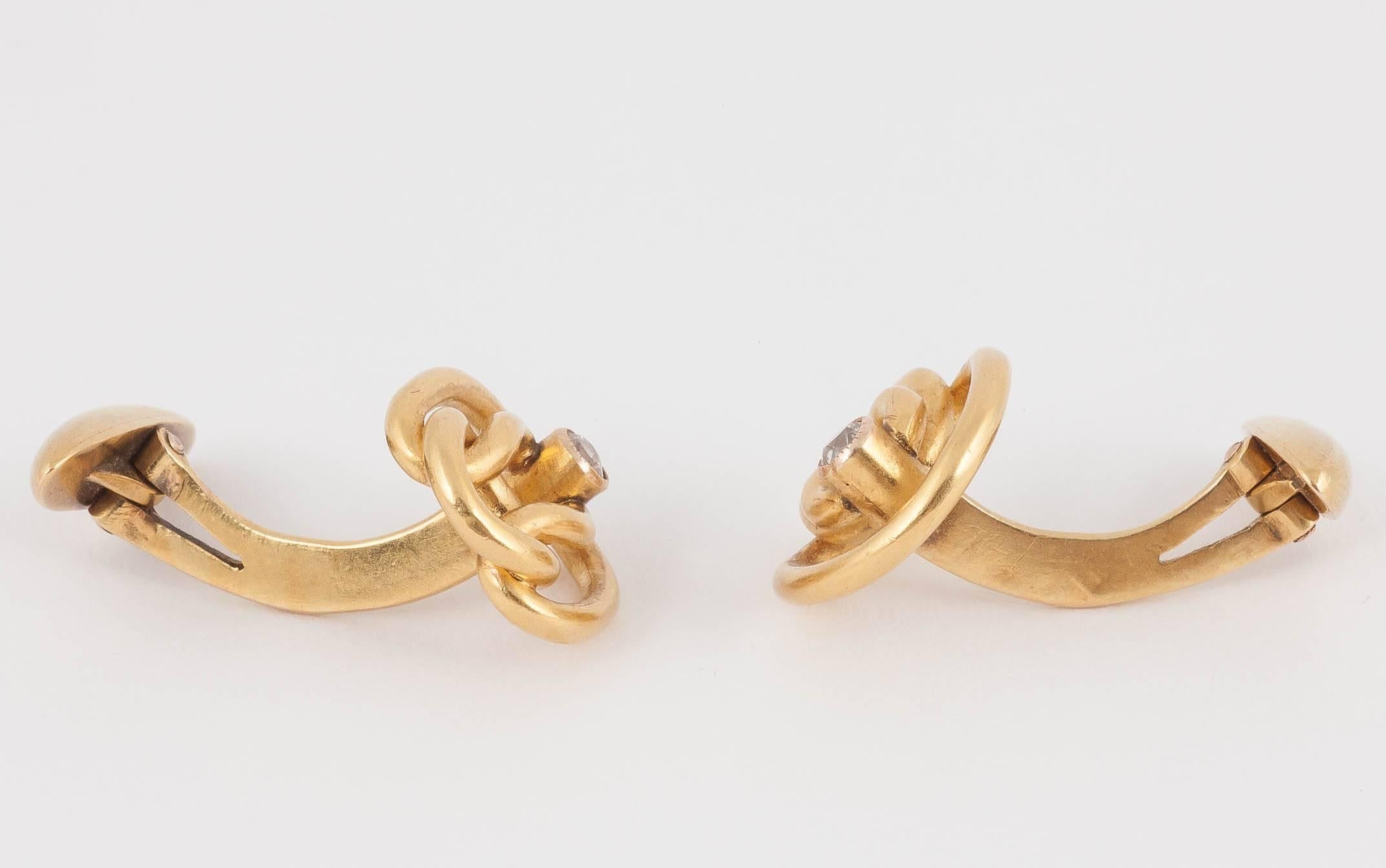An unusual pair of antique cufflinks in 14 karat yellow gold. Russian made in an openwork design of entwined knots with an old cut diamond collet. Single sided with swivel torpedo terminals.
Measures 15mm across.
Antique (over 100 years old),
Late