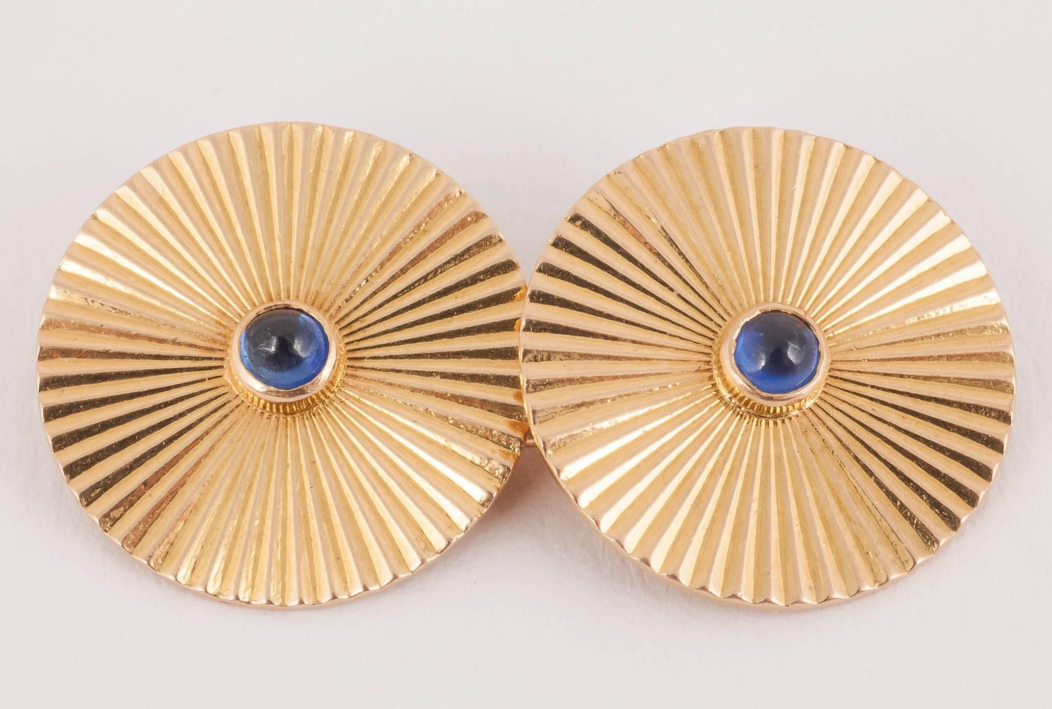 Pair of good coloured 18kt gold cufflinks of sunburst design with a central cabochon shaped sapphire, French marked with the eagle's head.  C 1950.