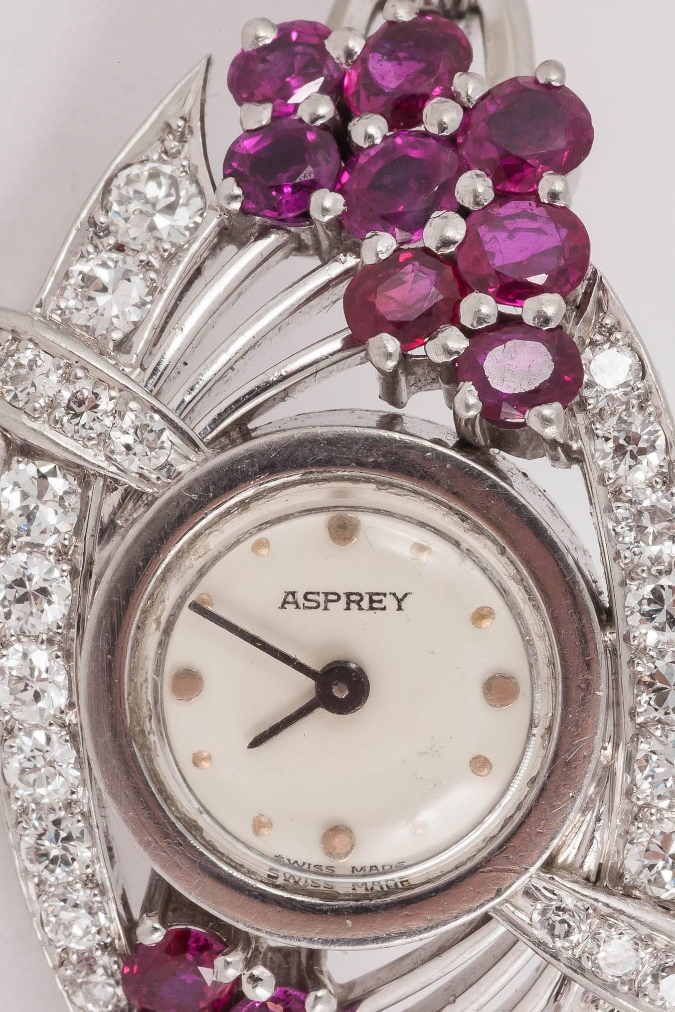 A fine quality ladies evening watch set with rubies and diamonds in 14ct white gold. Twin bracelet and clasp, lever jeweled with a mechanical movement.  Signed Asprey & Co. of London, Circa 1950-60.