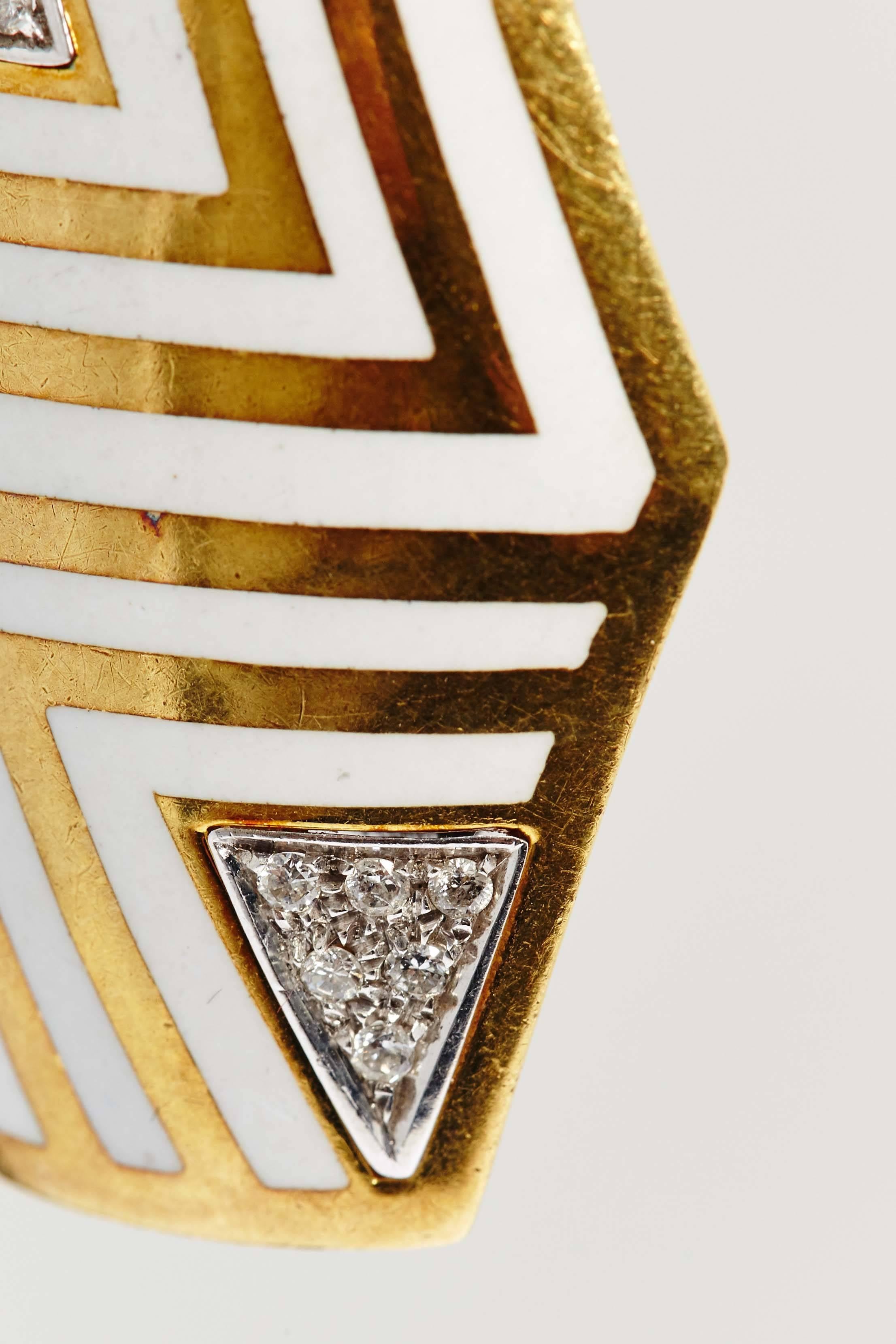 A chic pair of ear-clips of geometrical design, evoking the shape of shields, in 18kt yellow gold, decorated with with enameling. Made in Italy, circa 1970.
