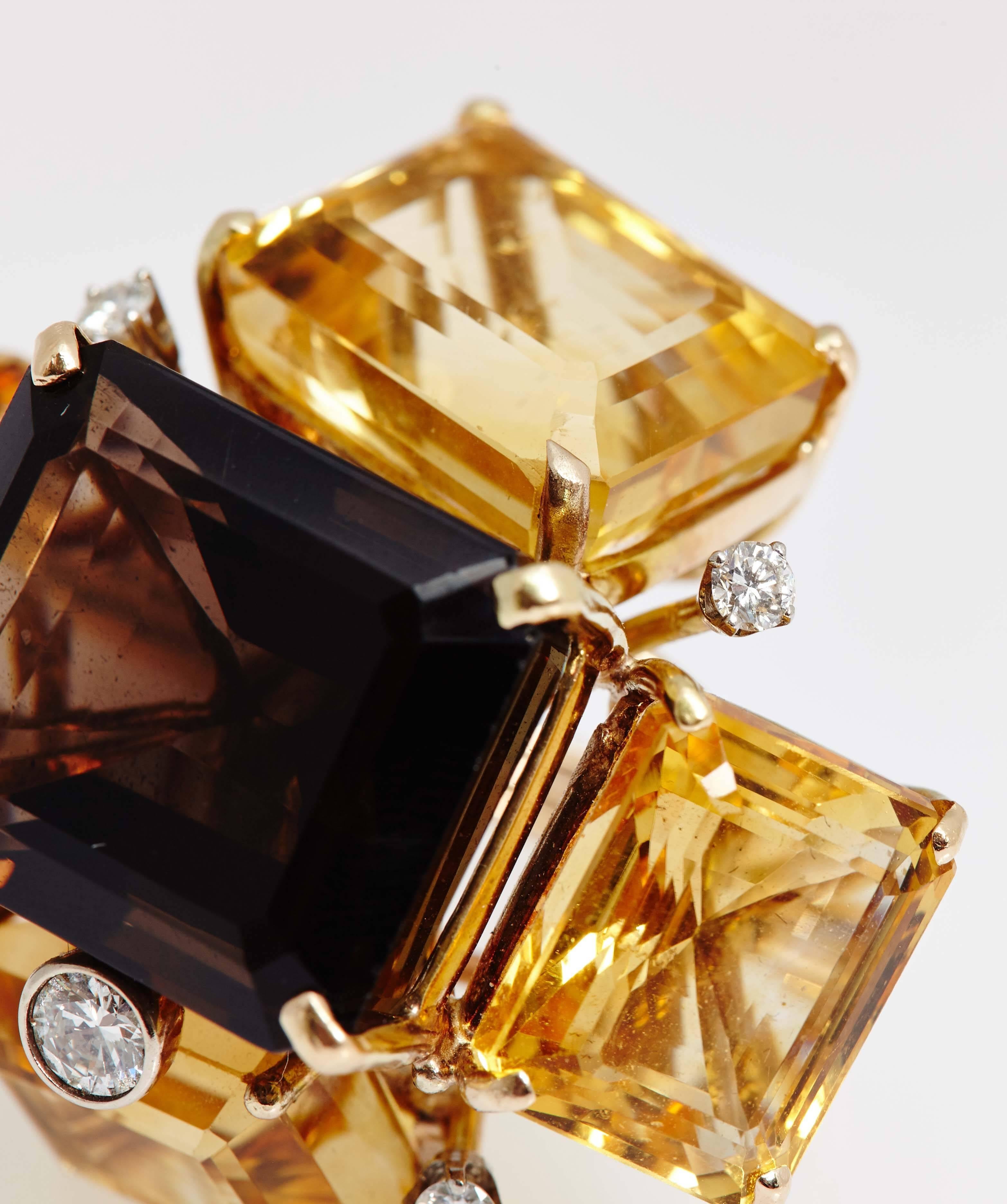 A chunky cocktail ring of architectural inspired composition, centering a large smoky quartz, sided by four citrines, highlighted with five small brilliant cut diamonds, mounted on 18kt yellow gold. Made in the United States, circa 1970.
