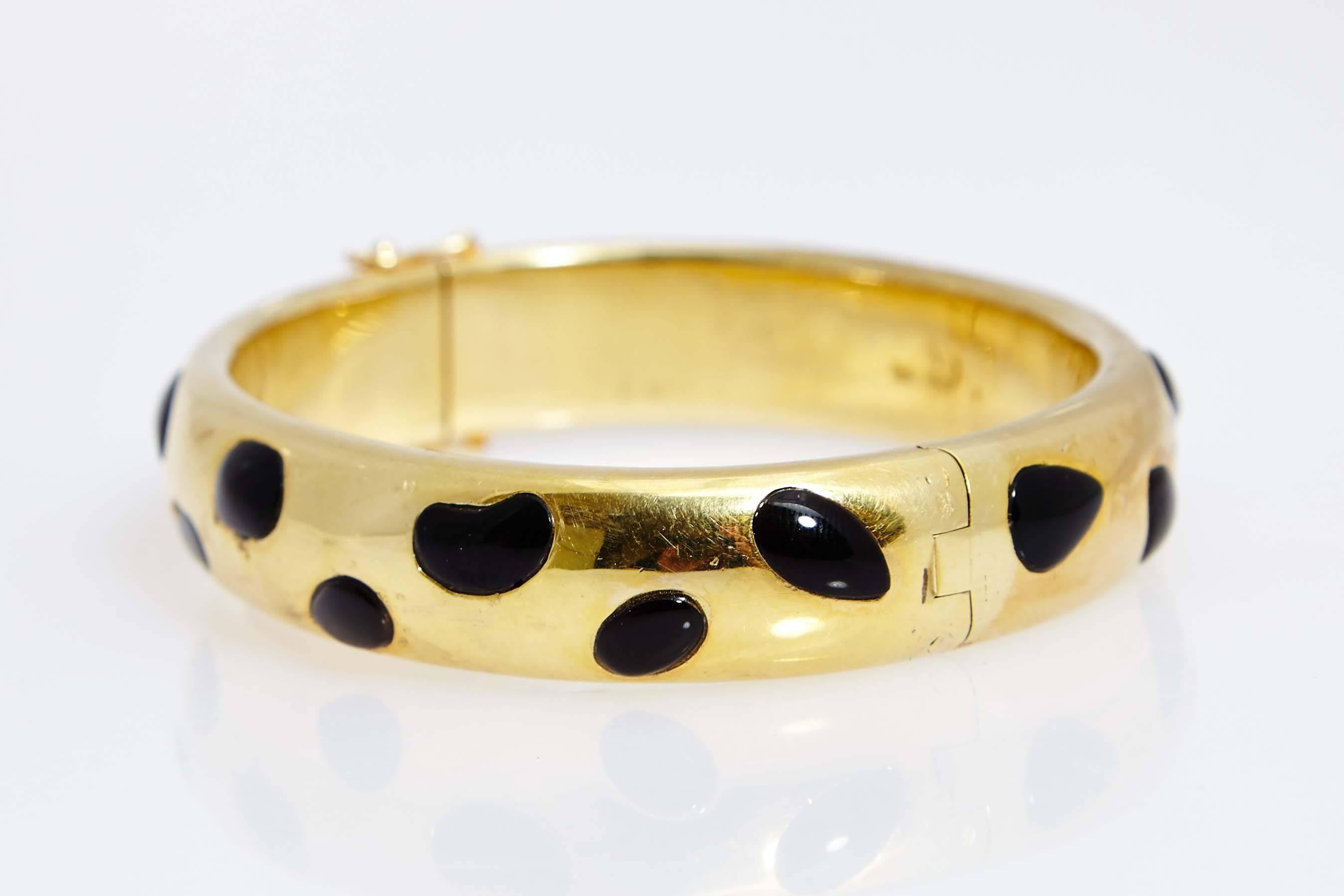 A peculiar 14kt yellow gold and onyx set, comprising bracelet and earclips, resembling a Leopard's skin. Made in the United States, circa 1970.