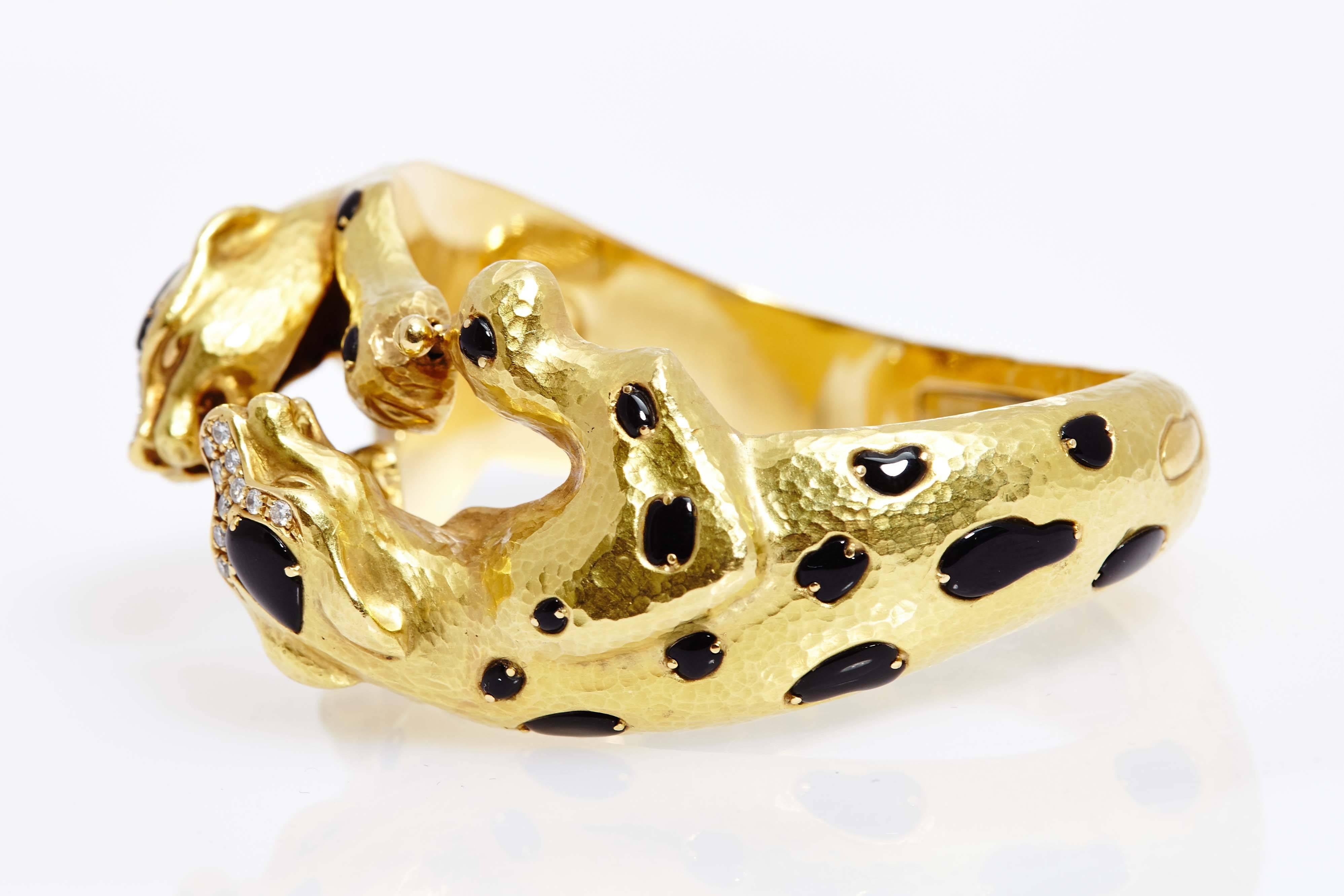 An animalier gold, onyx and diamond bracelet representing two fighting Leopards. Made in Italy, circa 1970. 

