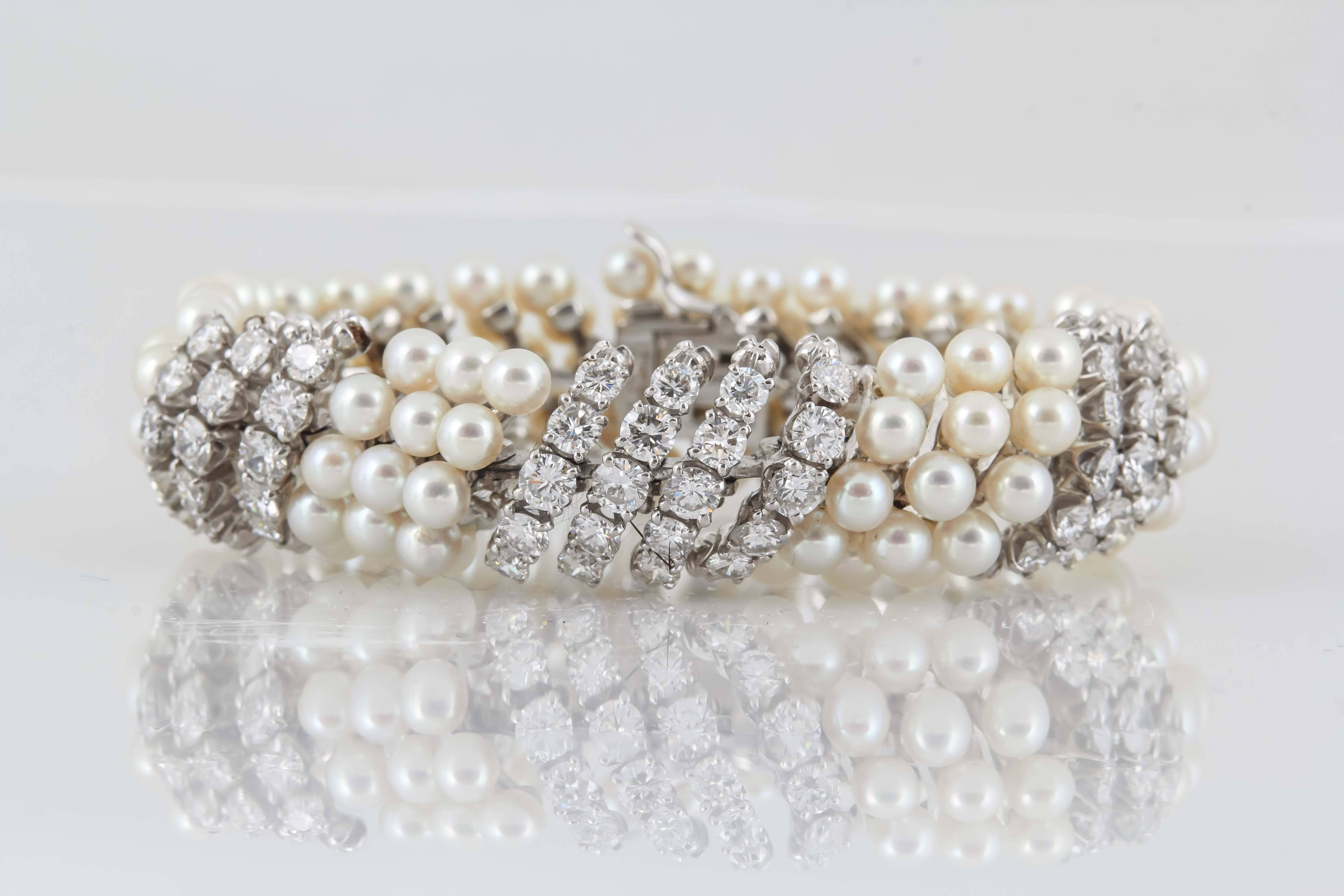Classic and elegant bracelet finely crafted in 18k white gold. Spiraling strands of pearls wrap around the wrist and then intertwine with twisting gold emblazoned with round brilliant cut diamonds weighing approx. 6.00 carats. Signed by David