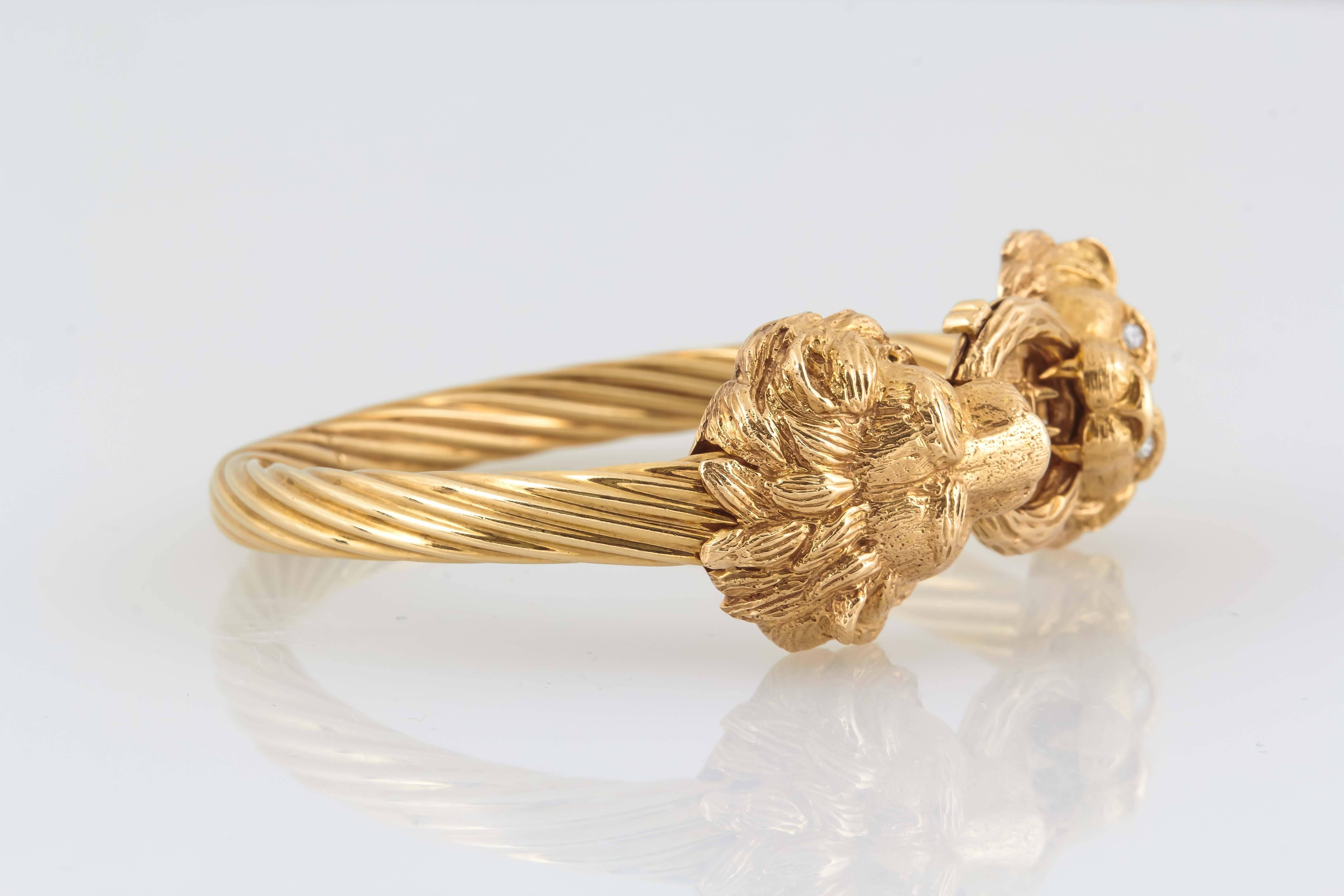 Van Cleef & Arpels 14K gold hinged bangle clasped by two diamond eyed lions.