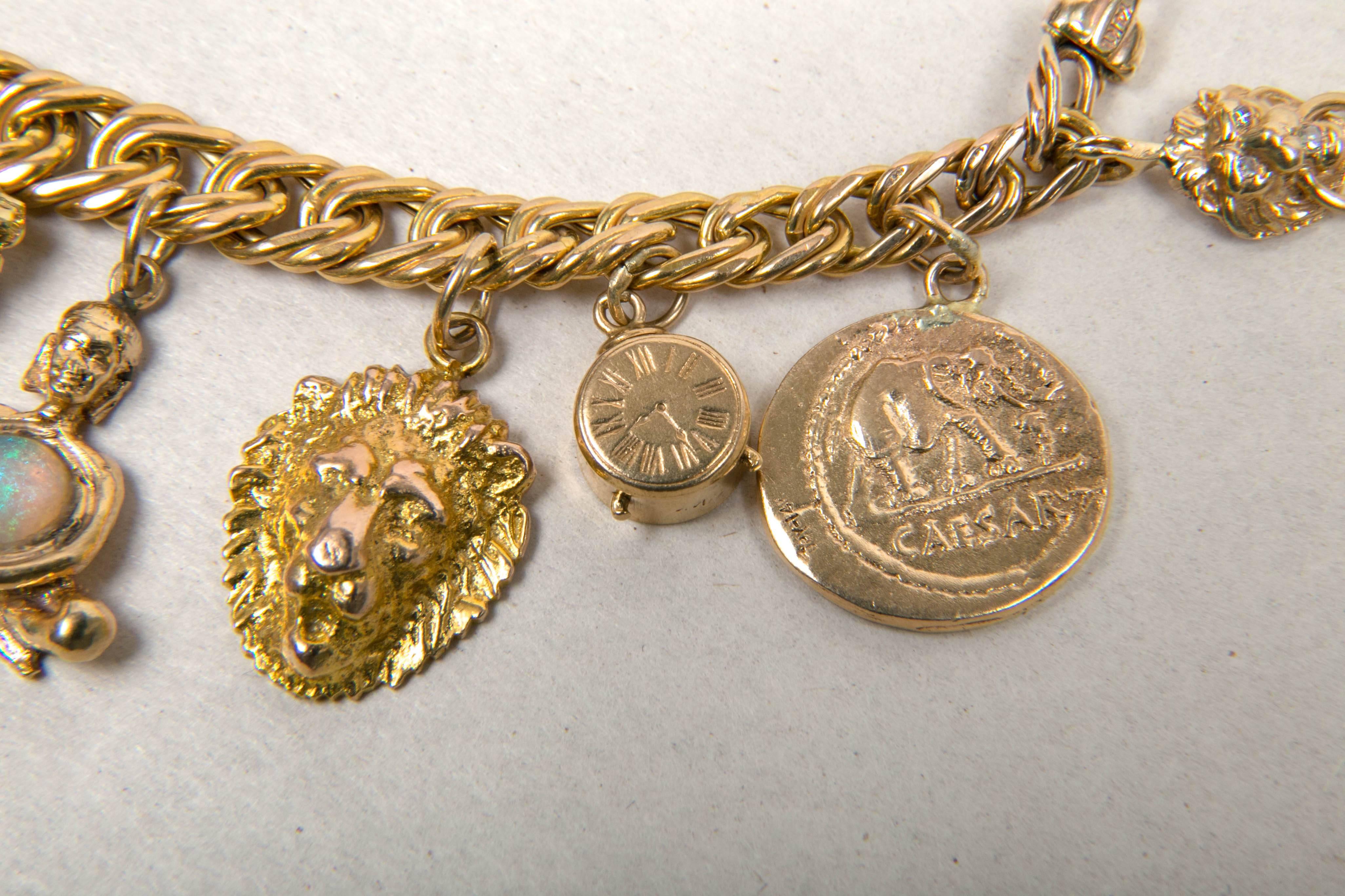 Collection charm bracelet in 14 k gold, gold round link bracelet holding 15 gold charms from 19th C through Mid Century. 