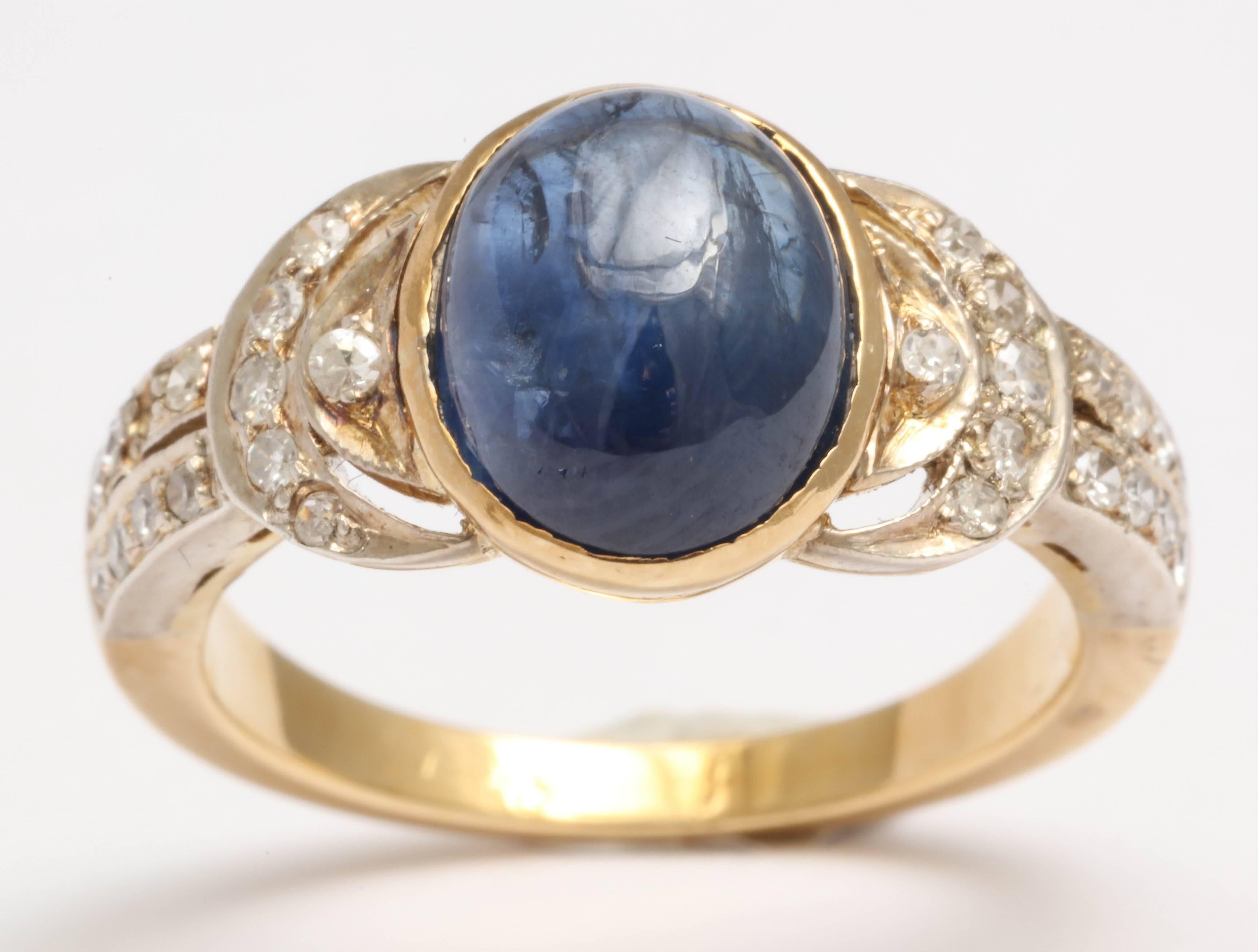 Sweet Oval Cabochon Sapphire, bezel set in 18kt Yellow Gold flanked on either side by single cut Diamonds set in Platinum.  28 Diamonds Total.   Size 5 - but can be altered.
Very sweet and delicate.

