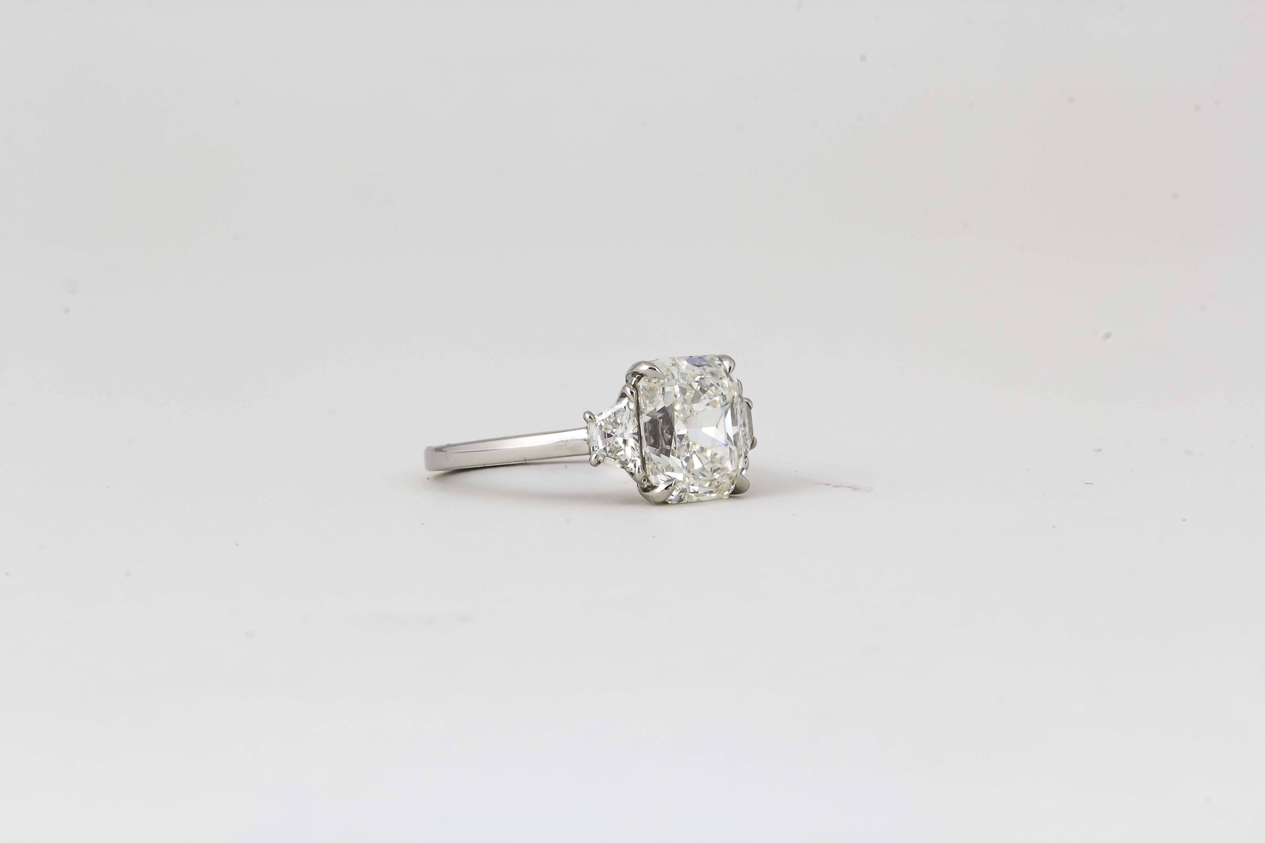 

Ein wunderschöner Diamant mit Strahlenschliff in einer zeitlosen, maßgefertigten Fassung. 

3,18 Karat zentraler H VS1-Diamant im Radiant-Schliff, besetzt mit passenden Diamanten im Trapezschliff mit einem Gewicht von 0,37 Karat. Eingefasst in