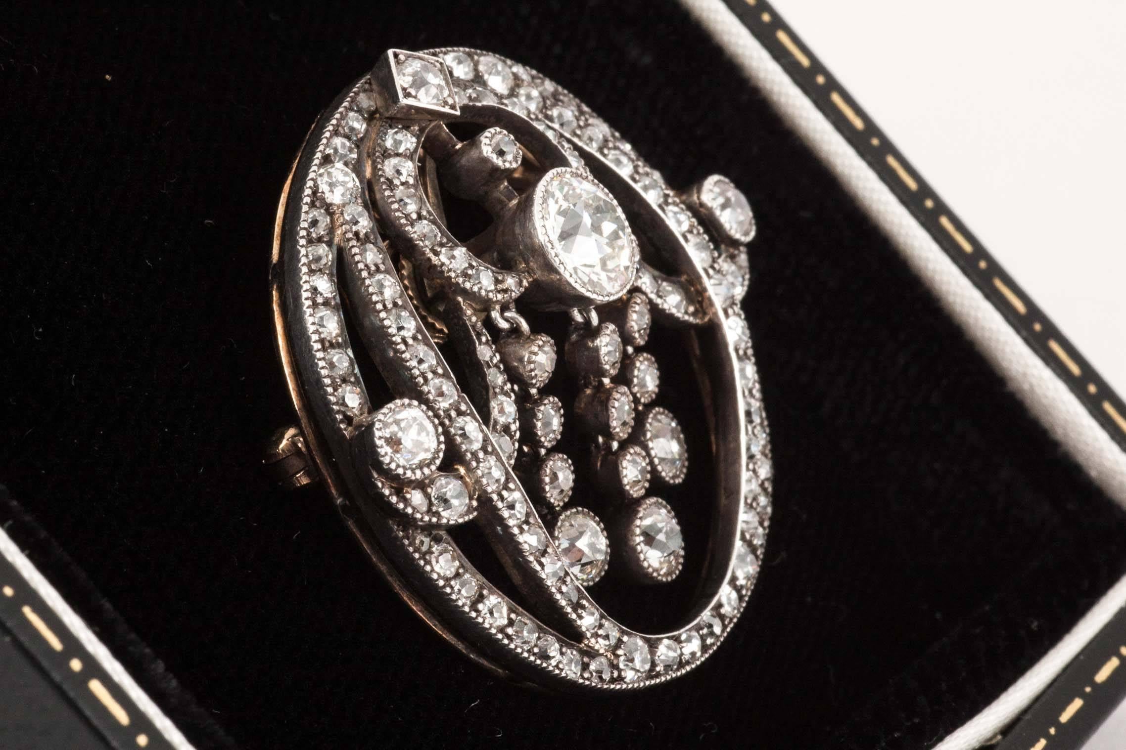 A bright quality,silver and gold mounted brilliant cut diamond brooch/pendant of very attractive form,the diamond set pendant fitting is detachable as well as the brooch fitting.The three, central ,four stone diamond drops swing. Approx 4 carats of
