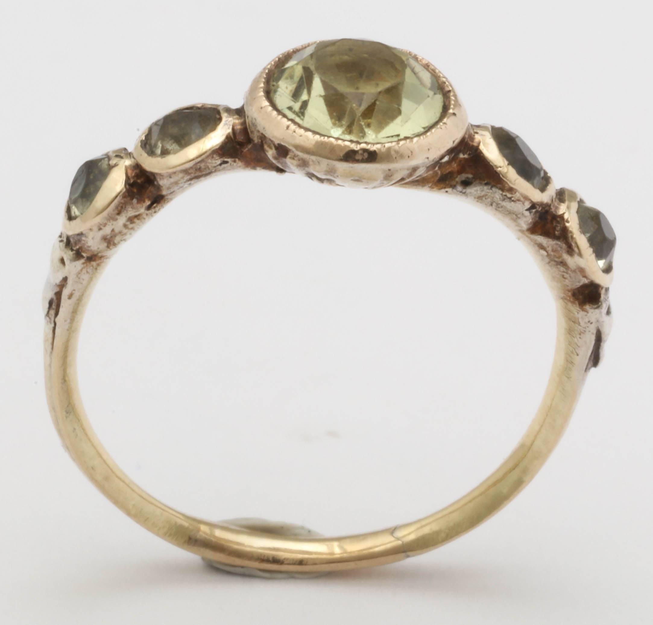 The chrysoberyl, with its vibrant light green coloration makes this ring a stunner. 5 stones set in a 15K closed back mount, made in England and dating to the Georgian era.