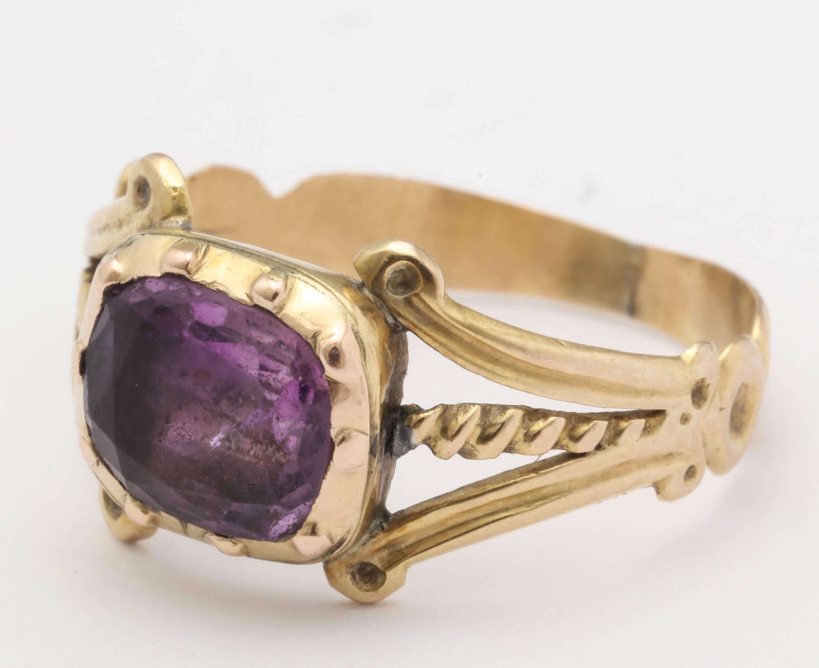 Lovely deep purple amethyst in a closed back setting was repurposed in the Victorian era and made into a ring with this open work, engraved shank. Likely starting life as a button, many pieces were repurposed throughout the years as occurs today. A