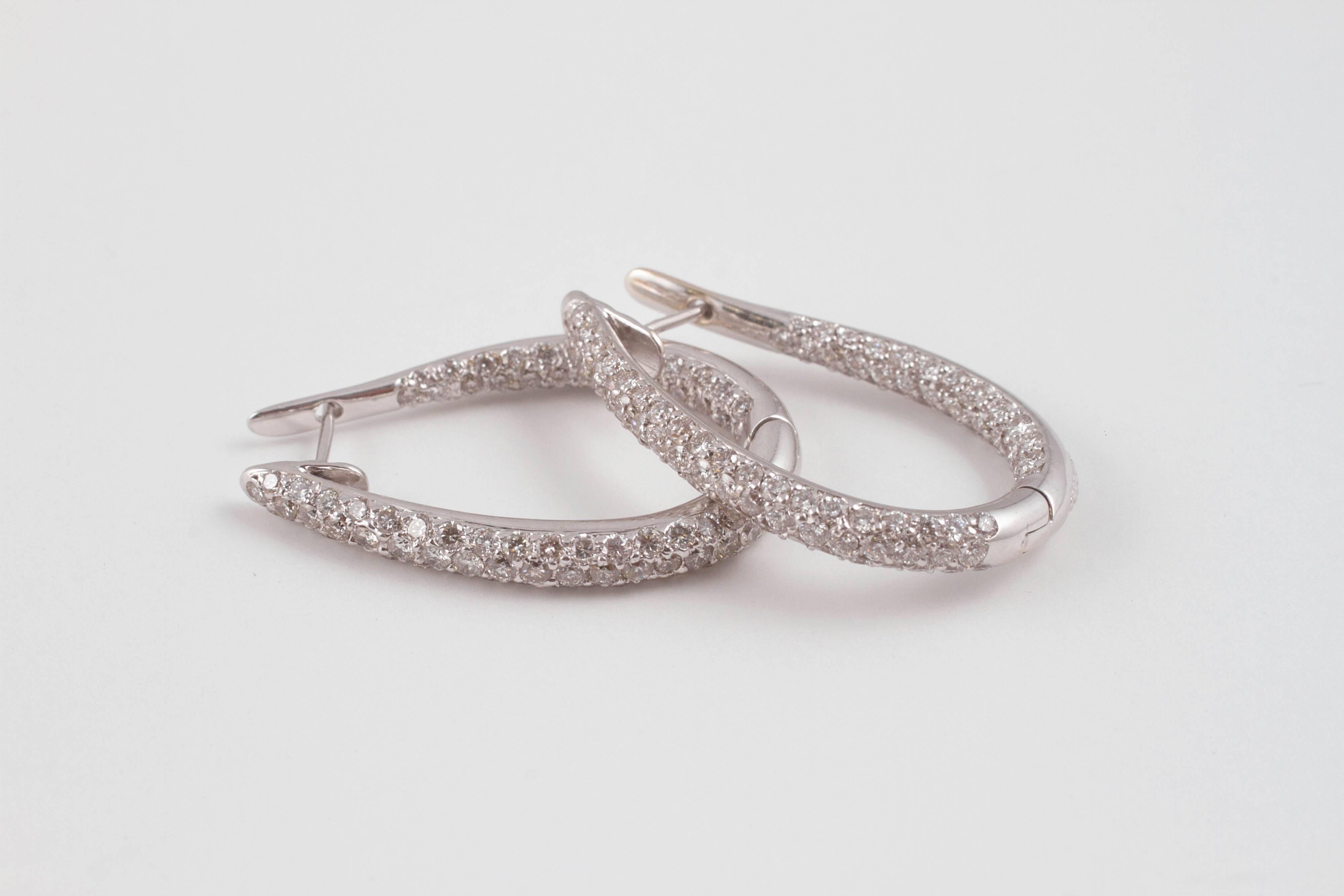 In an elongated oval form, with 1.75 cts of diamonds. Each earring is about 1 1/2 inches in length.