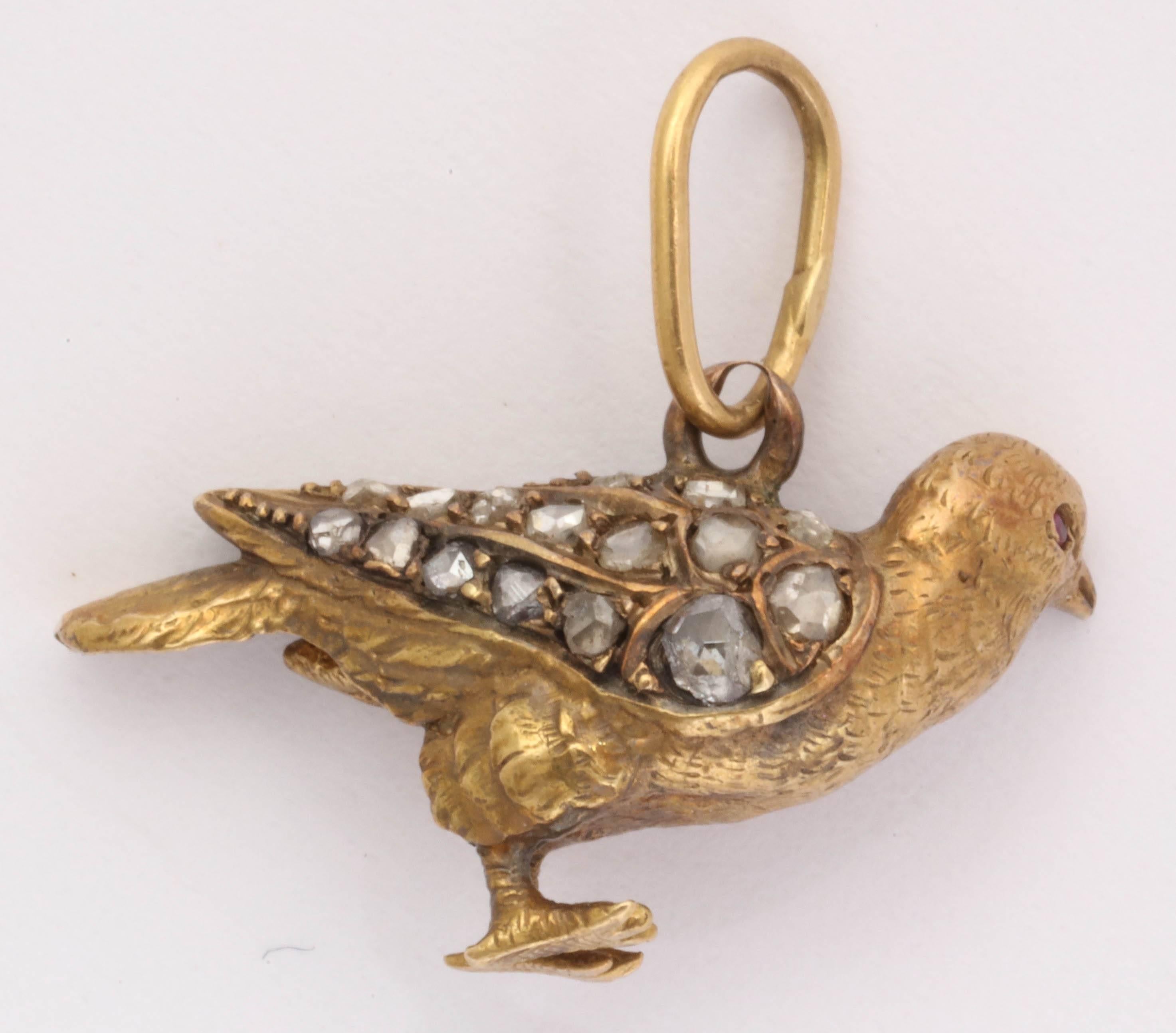 Unique and rare bird charm with rose cut diamonds on the wings and great detail in the carving. It is solid 18kt gold. The bale is a good size oval loop to accommodate a larger chain or cord.