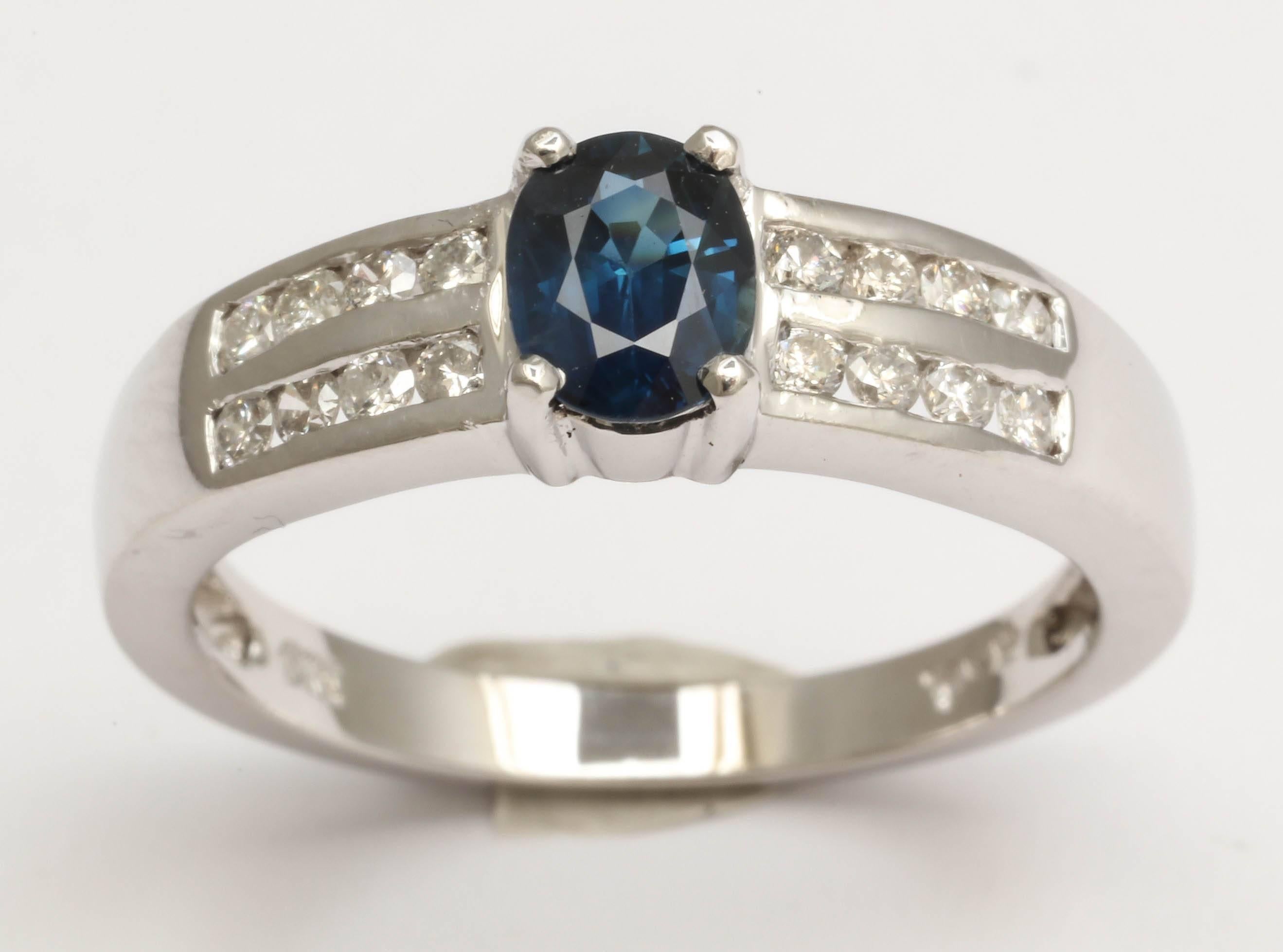 Beautiful blue oval sapphire, 4 X 6 mm., is flanked on both sides by 16 diamonds channel set on the shank. This ring is a size 7 and can be sized.