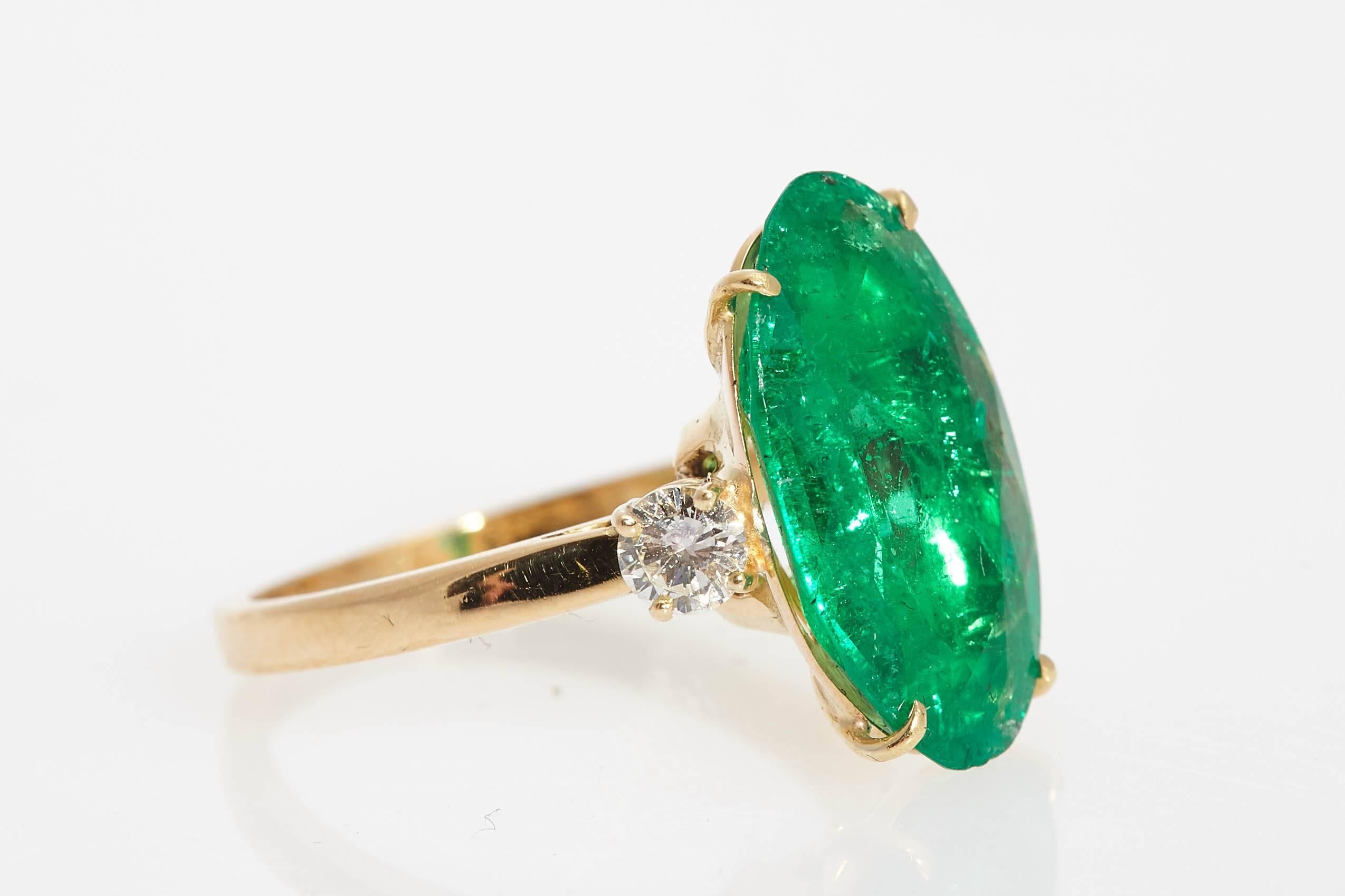 A ring showcasing a  Colombian emerald  of 4.3 cts (minor oil - Cisgem Certificate), sided by two small brilliant cut diamonds, on an 18kt yellow goald mounting. Circa 1980 