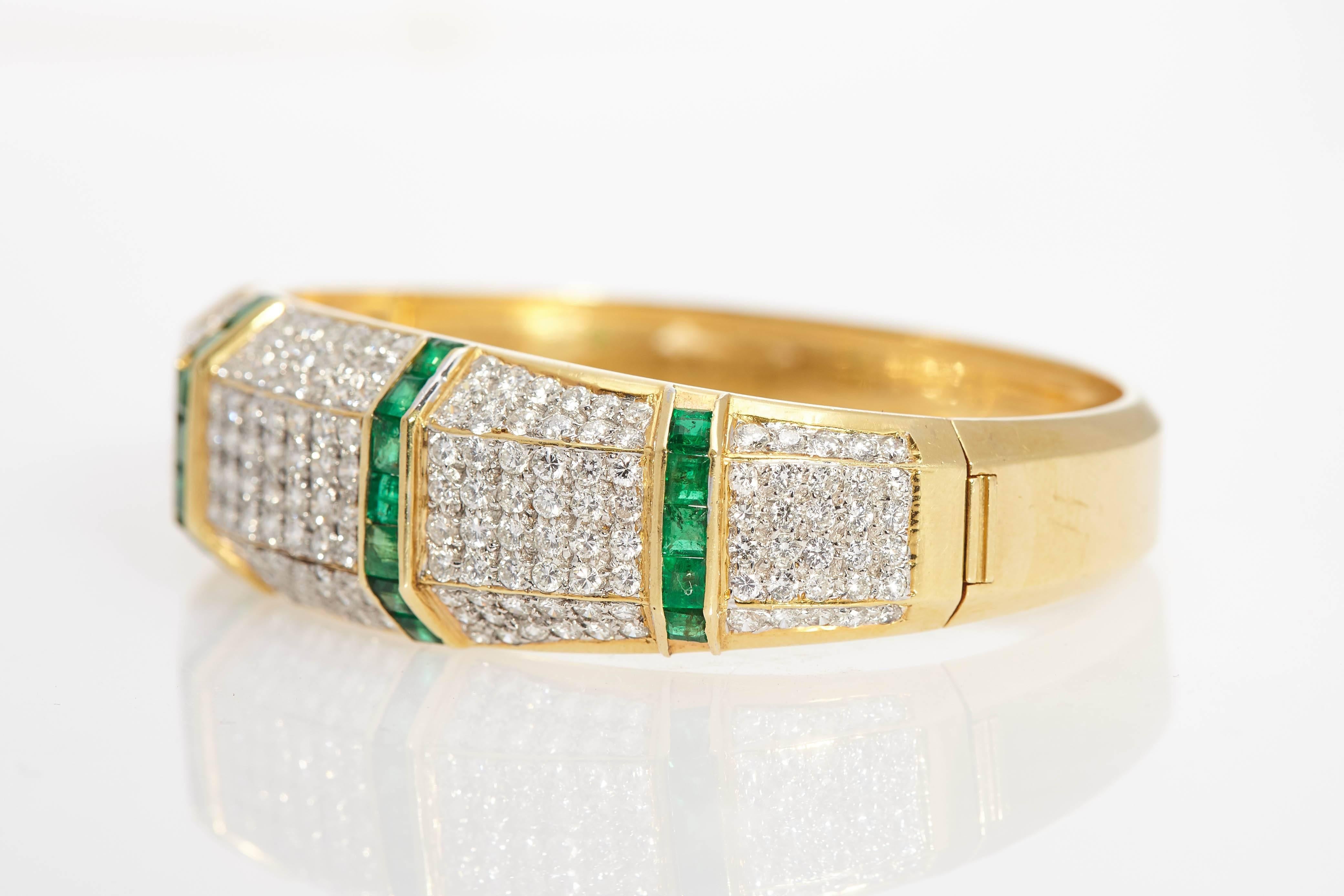 A fine brilliant cut diamond and squared cut emerald bangle bracelet. Made in Italy, circa 1970. 