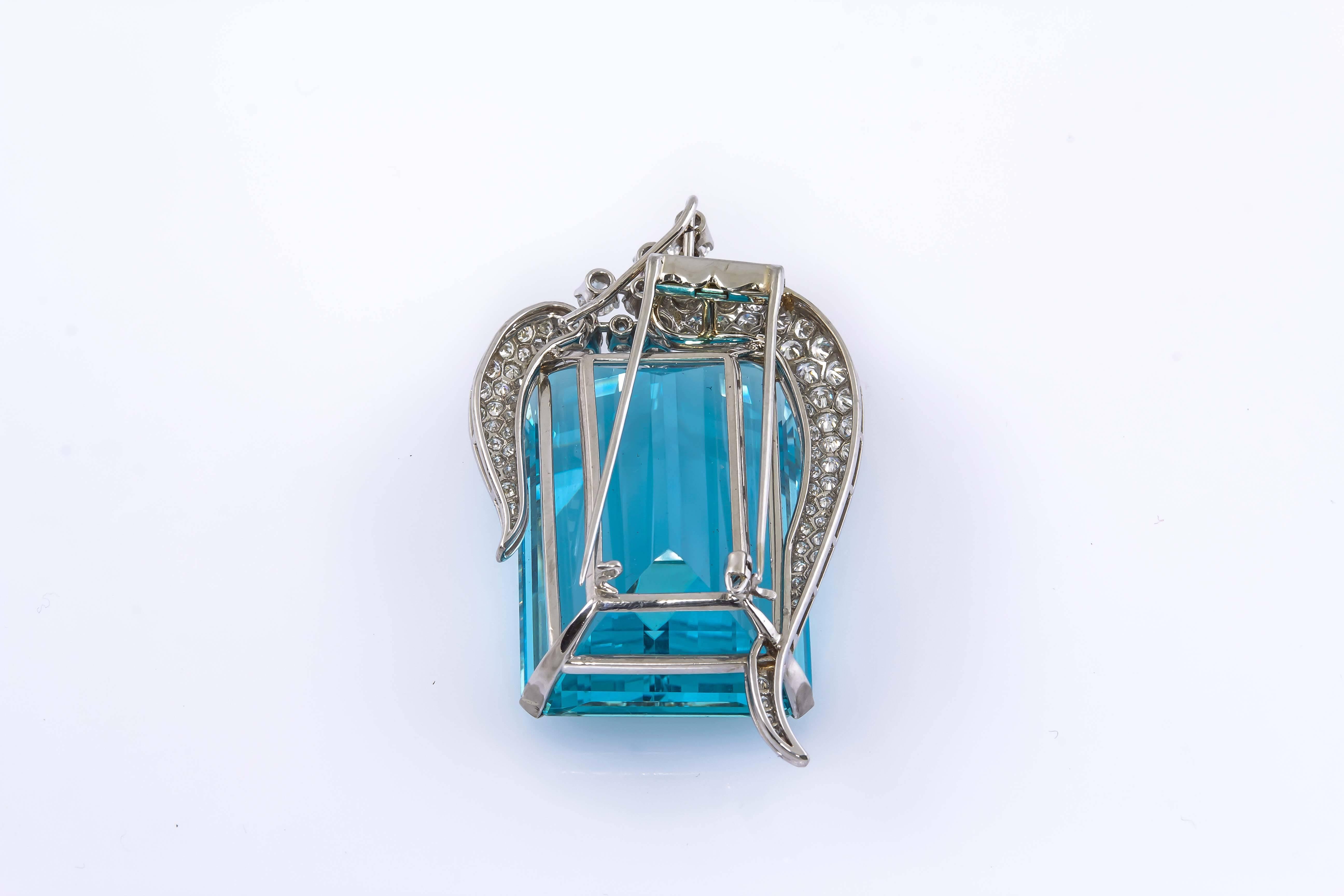 This stunning Art Deco Platinum brooch features a 120 carat aquamarine. 
It is is a vibrant and amazing stone. The brooch is accented with different sized round brilliant diamonds totaling 5.00 carats. A hidden bail is attached to the back if you'd