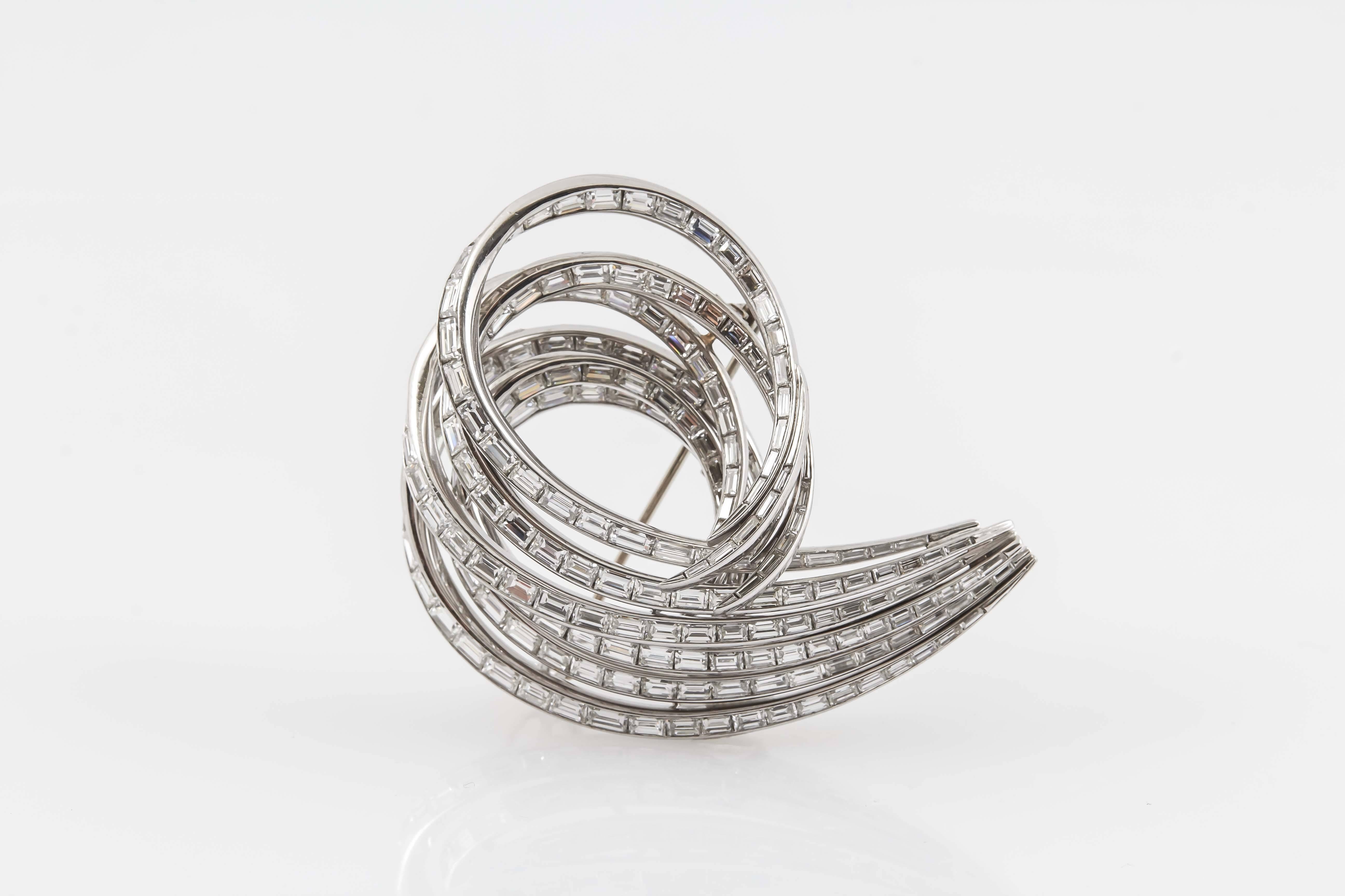 Diamond scroll brooch, set with different sized baguette-cut diamonds weighing a total of approximately 25.00 carats, mounted in platinum. 