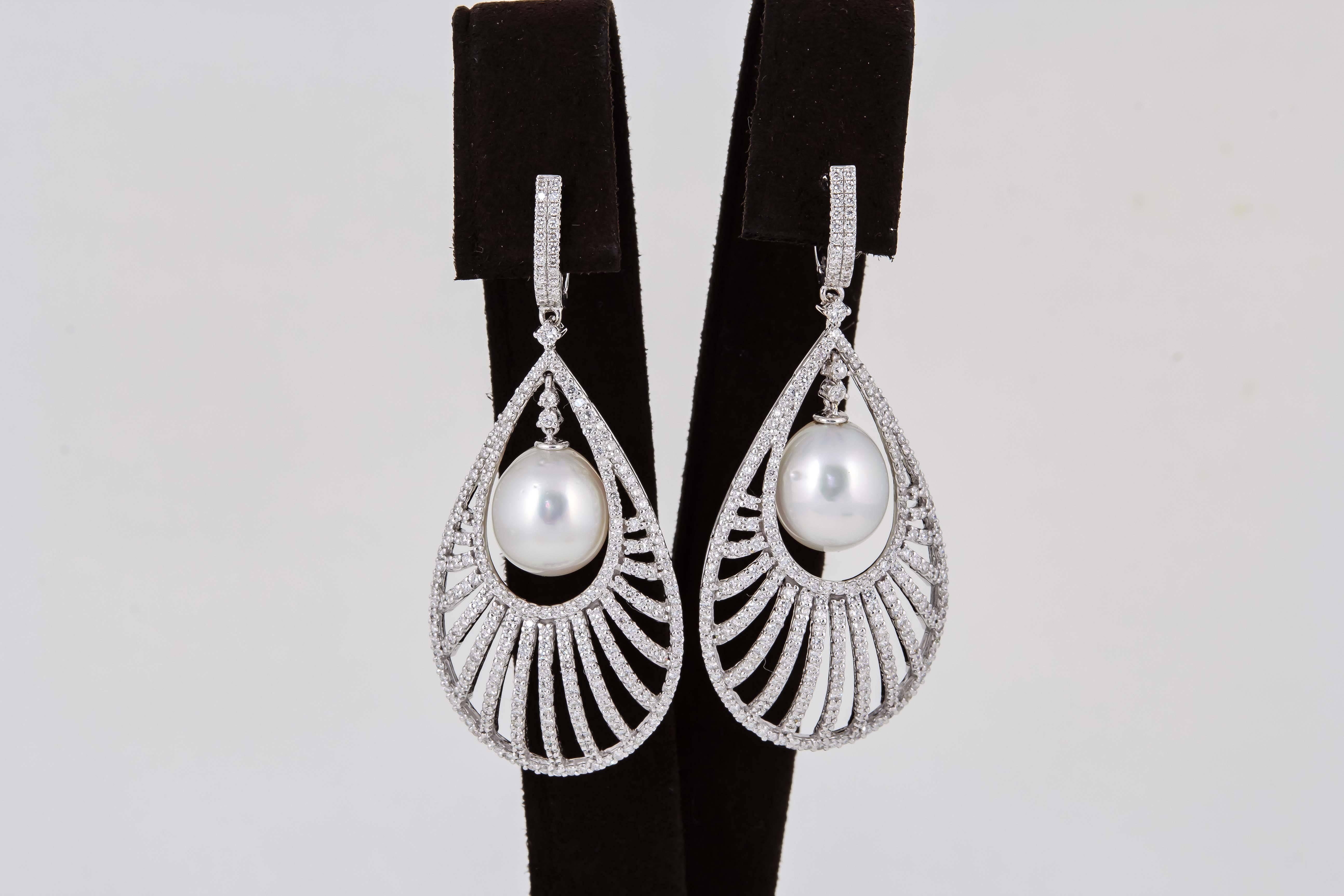 

A gorgeous high fashion pair of diamond and pearl earrings set in 18k white gold. 

4.09 carats of F color VS clarity diamonds. 

Approximately 2.36 inches in length and 1 inch at its widest point. 

The earrings have a slight dome effect which