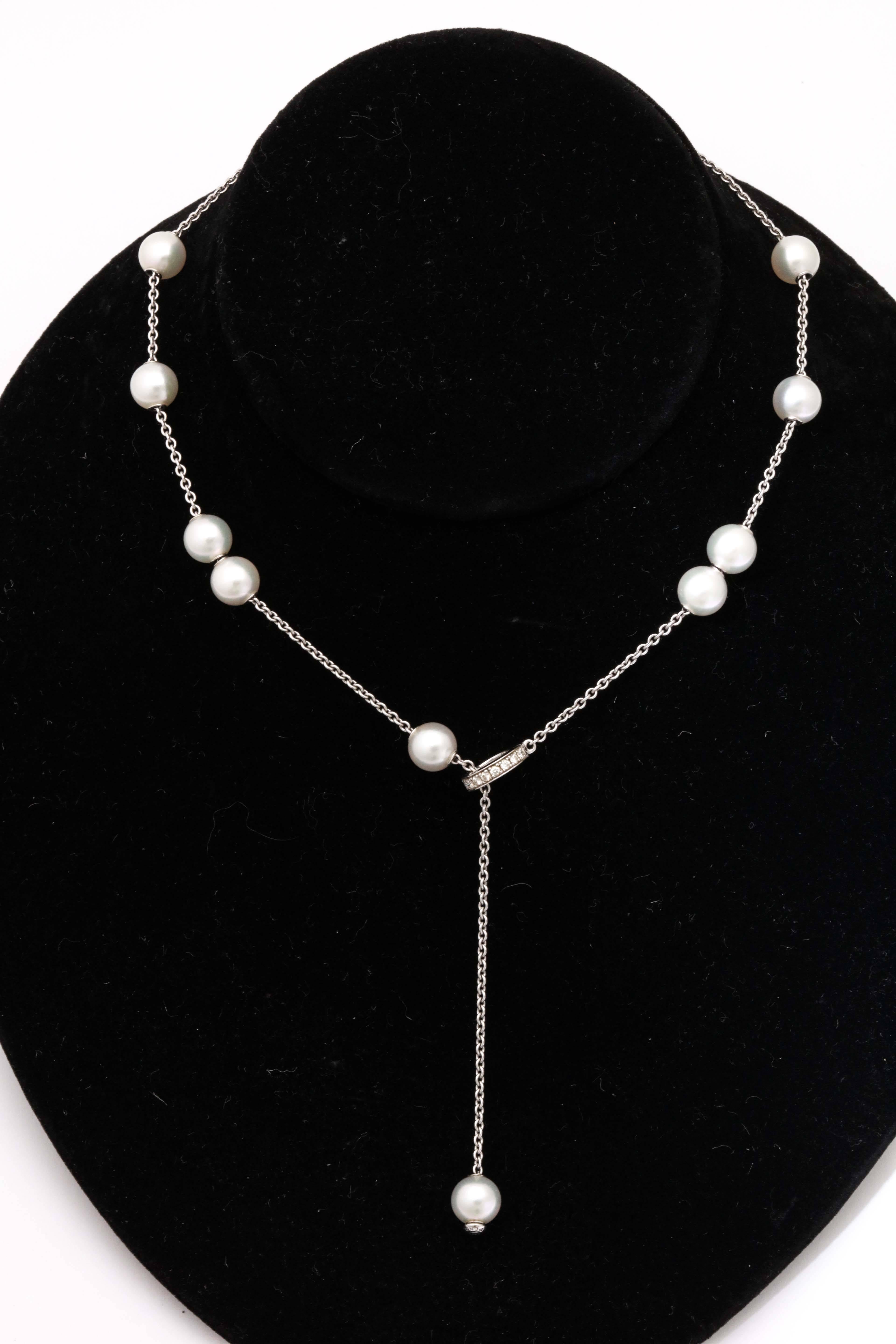 Magically made  so that each of the 11  Pearls  can slide up or down the white Gold chain  and land at whatever point you desire.  Final Pearl goes through a Diamond set Circle which opens on a hinge.  Each Pearl just short of being 8mm.
Signed M