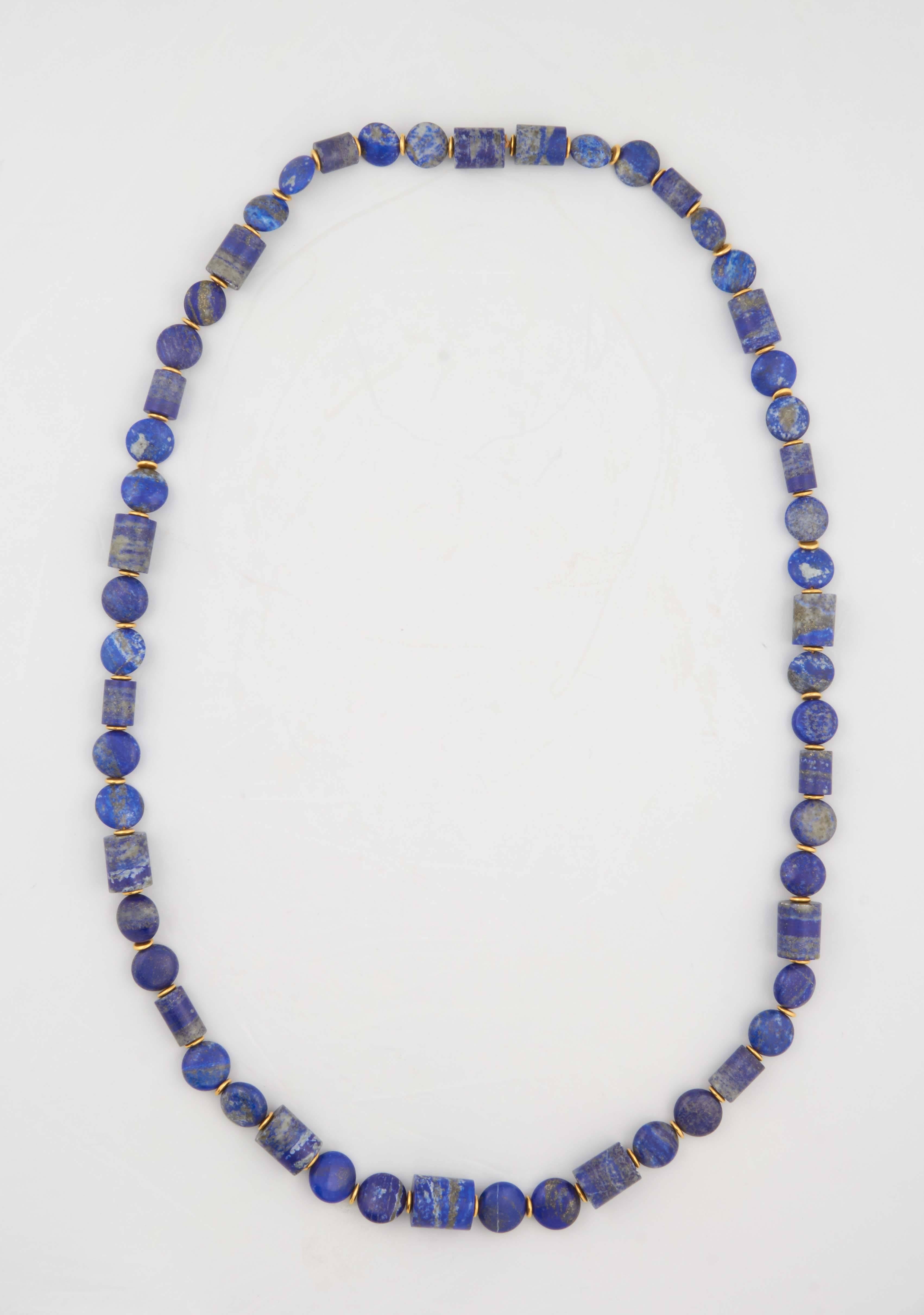 A honed lapis lazuli bead necklace composed of carved lapis lazuli tube beads and carved lapis lazuli smartie beads. The beads are separated by 18kt yellow gold rondelles.
Length: 45 inches.