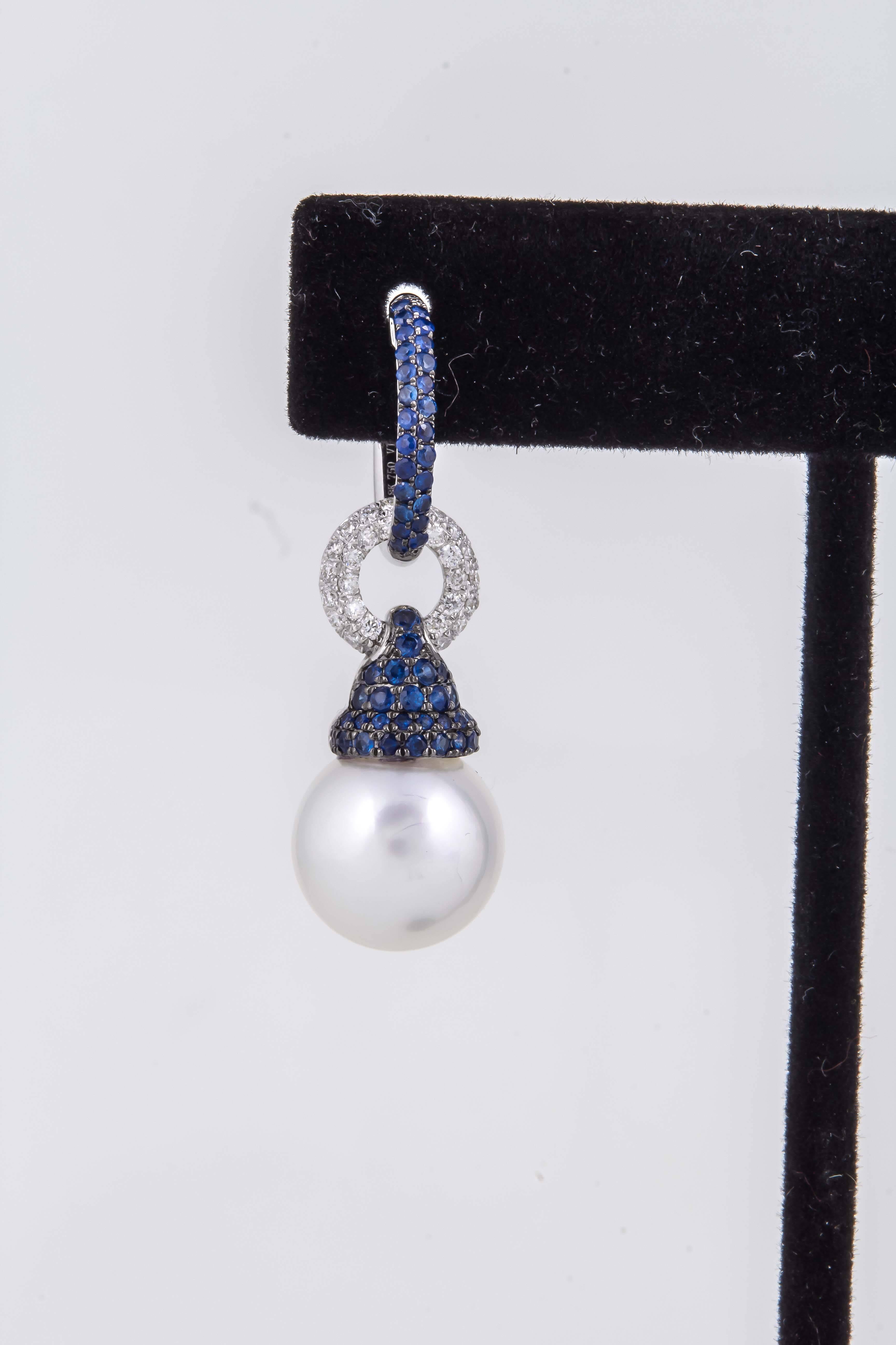 
Beautifully crafted in 18K white gold 2 south sea pearls measuring, each, 
12-13 mm with great quality and high luster.
The top hoop part can be worn separately as Huggies
Diamonds: 0.52 Carats
Sapphires: 1.05 Carats
3.5 cm long